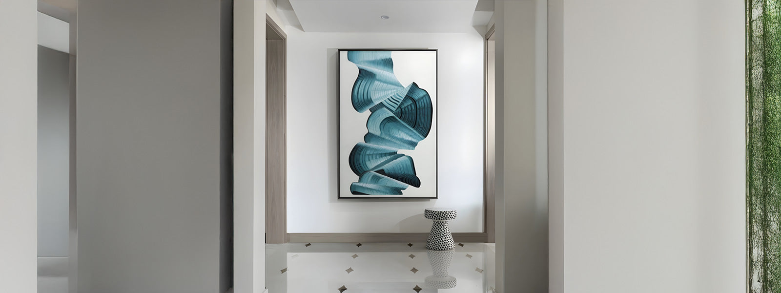 Large framed enamel art piece featuring flowing teal and blue ribbon-like forms on a white background, displayed in a modern white hallway above a dotted stool.