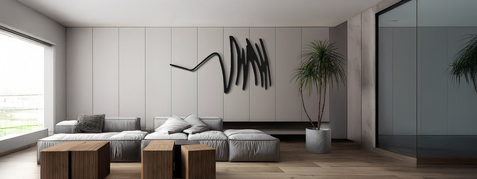 Abstract black iron wall art with sweeping scribble-like lines on a light gray paneled wall in a modern living room with gray sofa and wooden side tables.