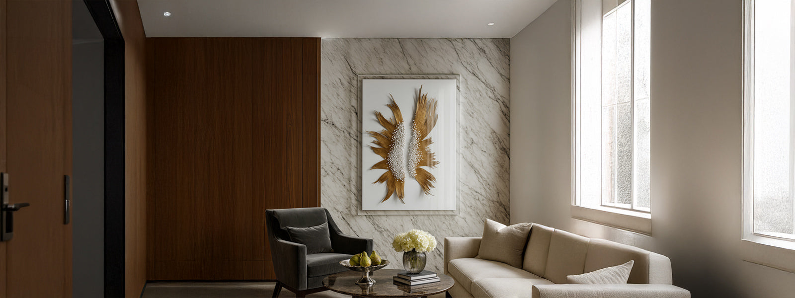 Framed mixed media wall art with golden feather-like forms and white bead clusters on a marble wall in a modern living room.
