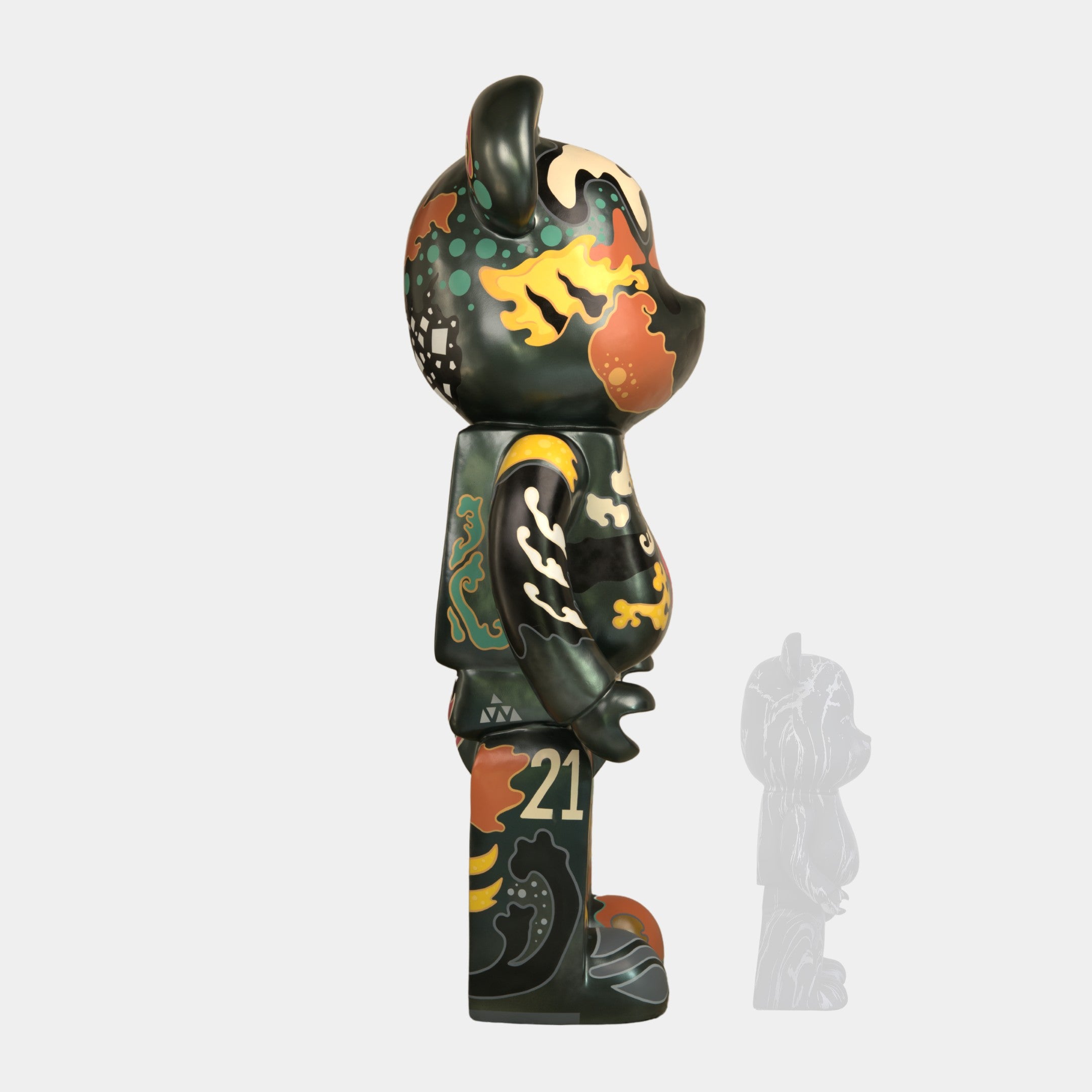 A side view of the Inside Appears Outside Bear Sculpture - 50cm by Giant Sculptures, a limited edition piece with an abstract green, yellow, orange, and black pattern by Jirayu Tantrakul, featuring the number 21 and decorative motifs.