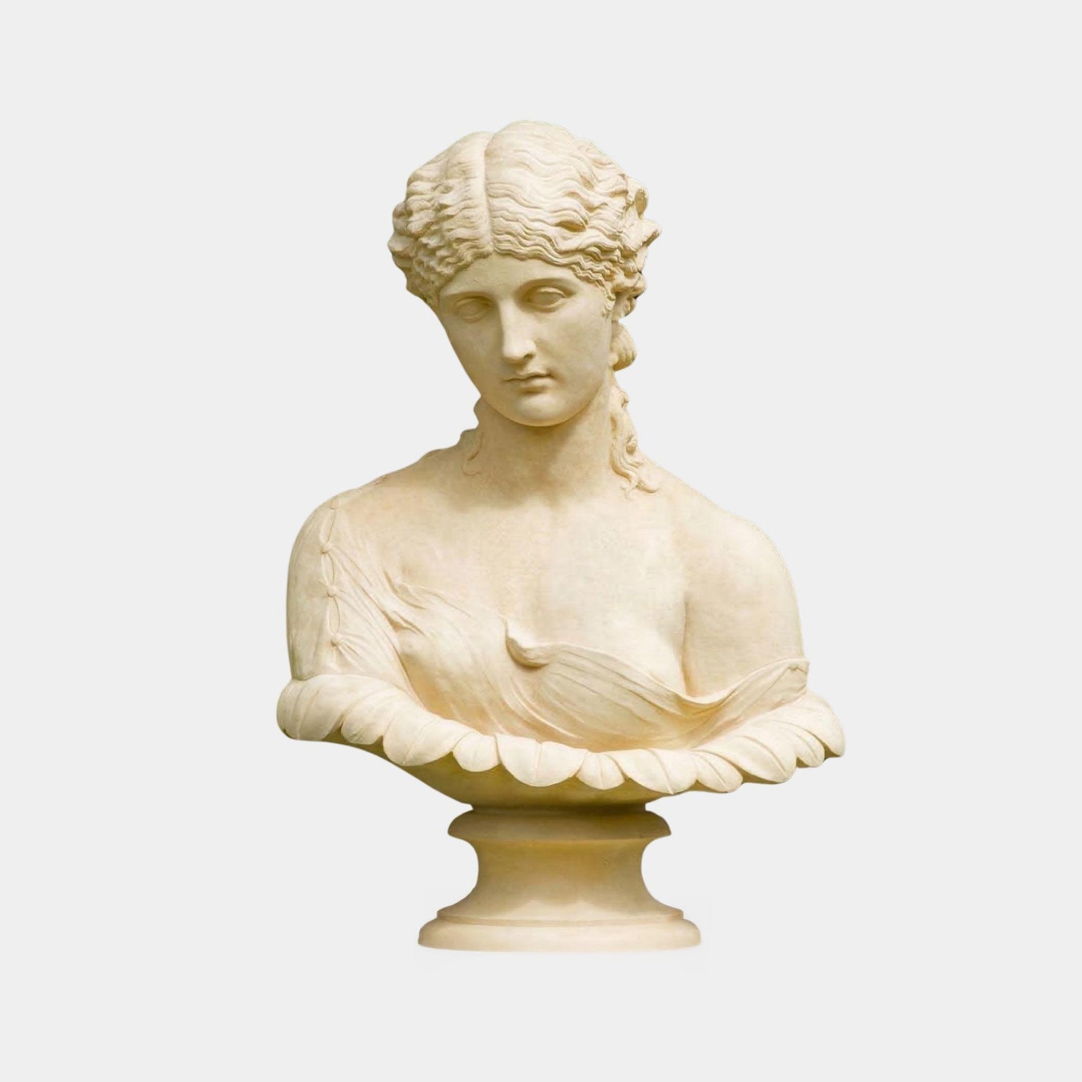 The Classical Female Marble Bust Sculpture - 70cm by Giant Sculptures features a woman with wavy hair, downcast eyes, and refined features, draped in fabric atop a decorative base against a light background.