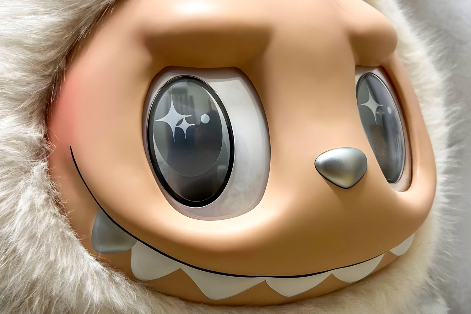 Close-up of a large, Labubu cartoon-like creature with shiny, starry eyes, a wide toothy grin, a small silver nose, and fluffy white fur framing its face.