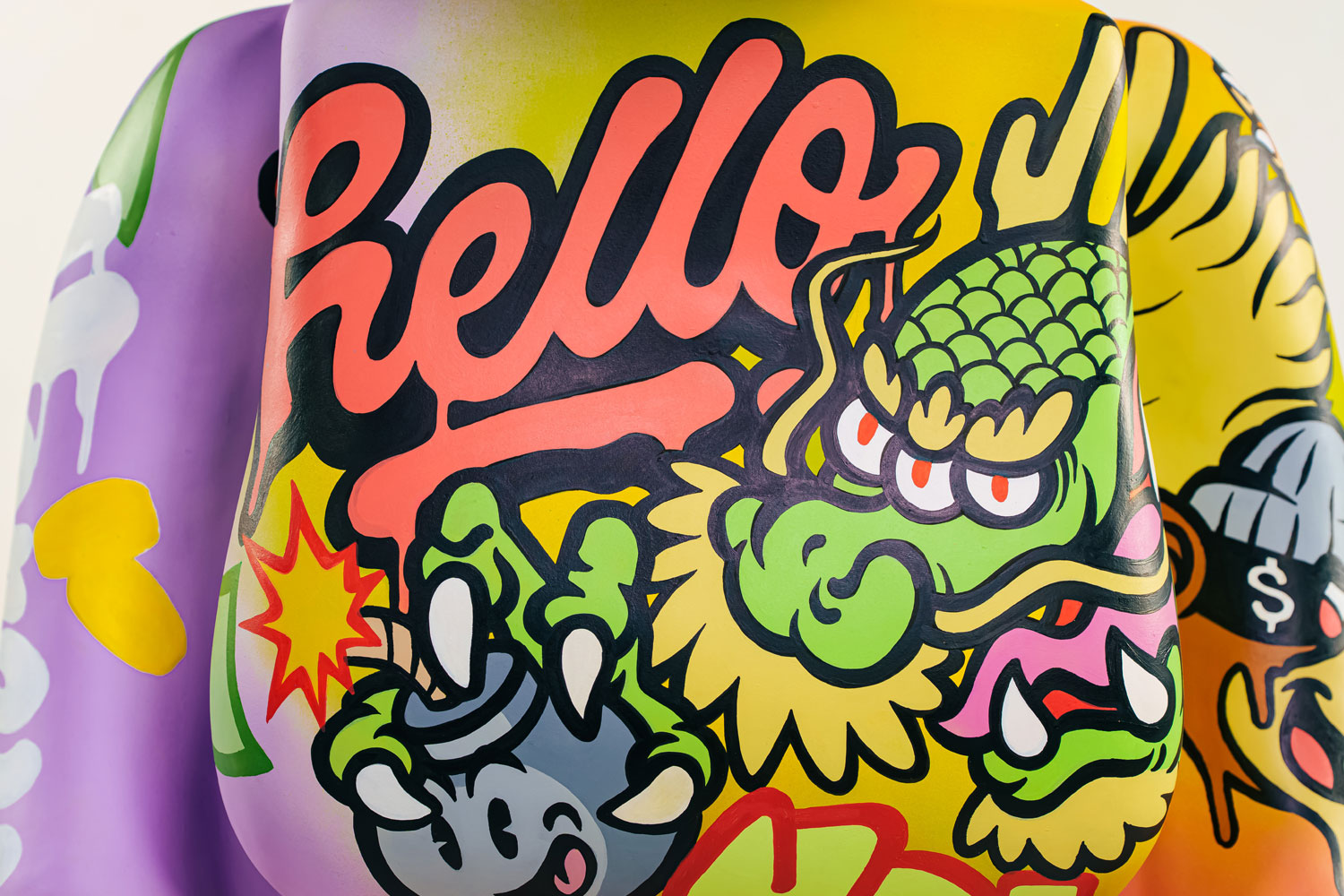 Colorful graffiti-style artwork with the word “Hello” in bold red script, a green dragon, and various cartoon-like elements, including claws, stars, and graphic shapes on a purple and yellow background.