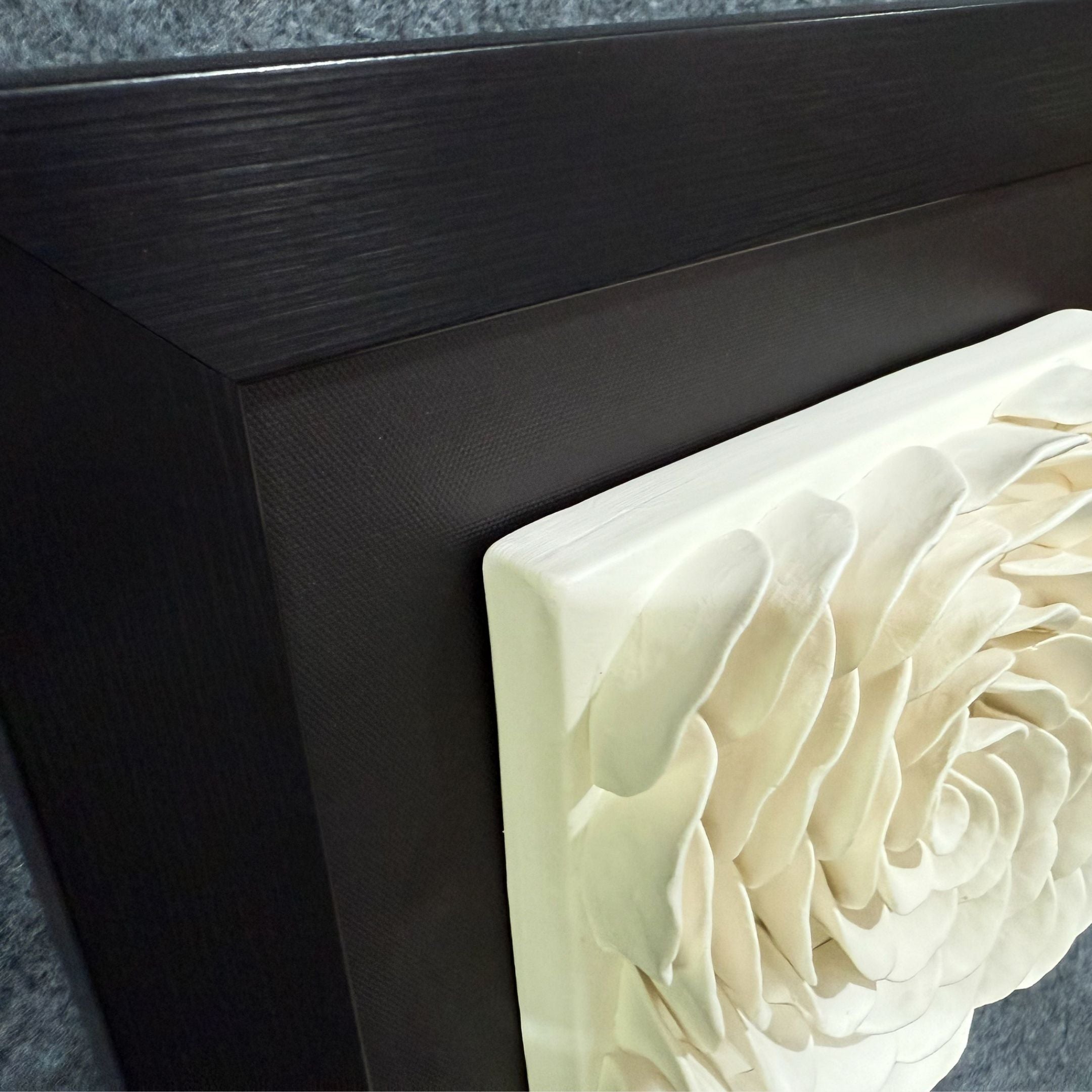 Close-up of the Harmonia 3D Rose Wall Installation by Giant Sculptures, featuring a layered white flower with textured petals set in a modern black frame—a striking floral wall statement.
