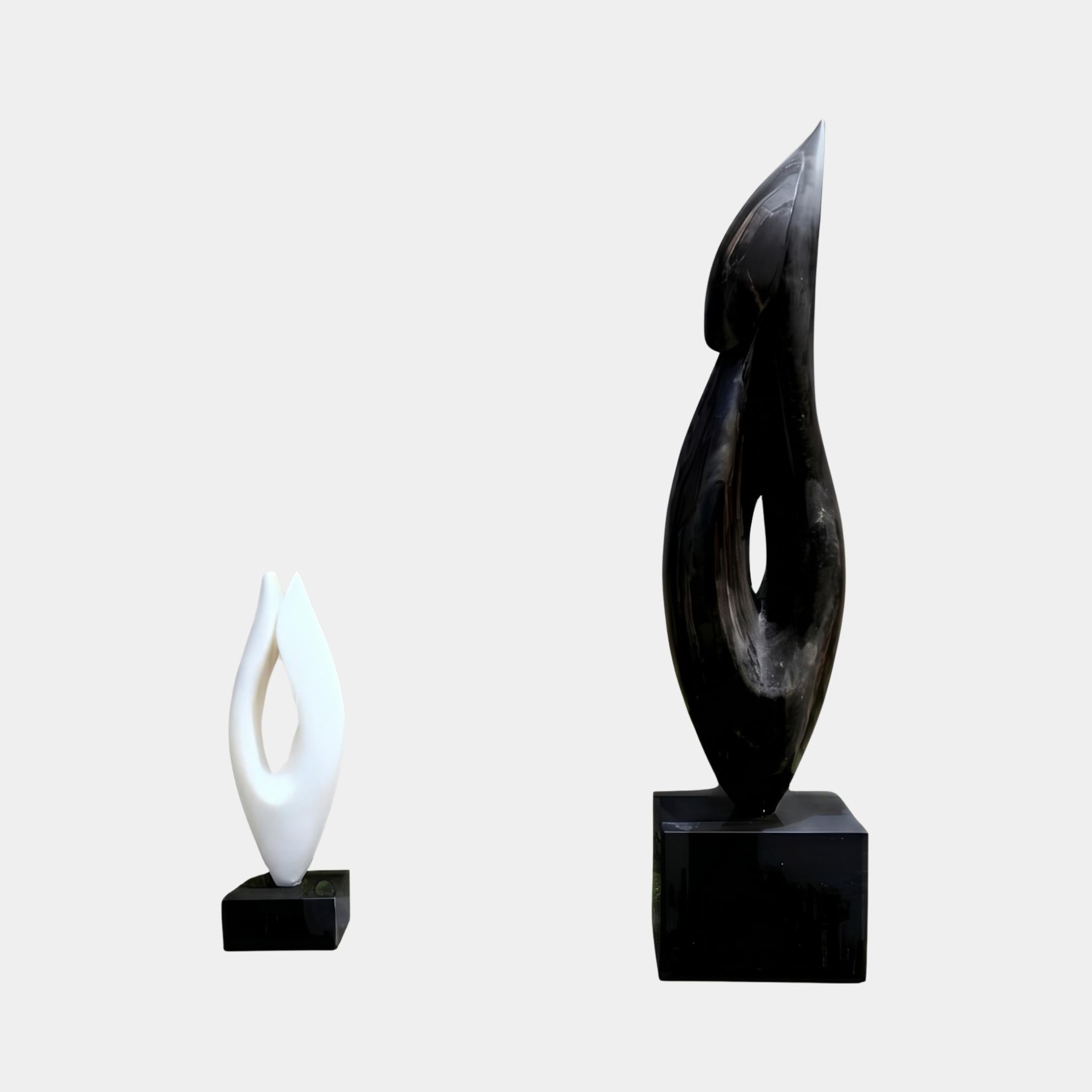 Abstract Flame Marble Sculpture by Giant Sculptures shown in both sizes side by side, the 55cm white version beside the 120cm black version on black bases.