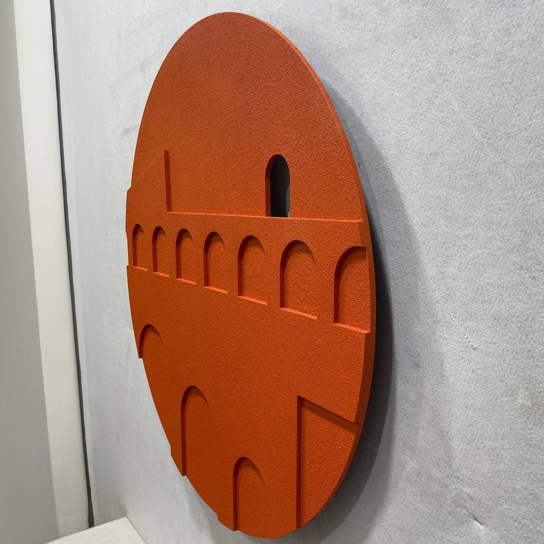 Angled side view of the Arcuza Terracotta II Wood Carving Sandstone 3D Wall Art, showing the carved arches and offset window cut-out against a light grey wall.