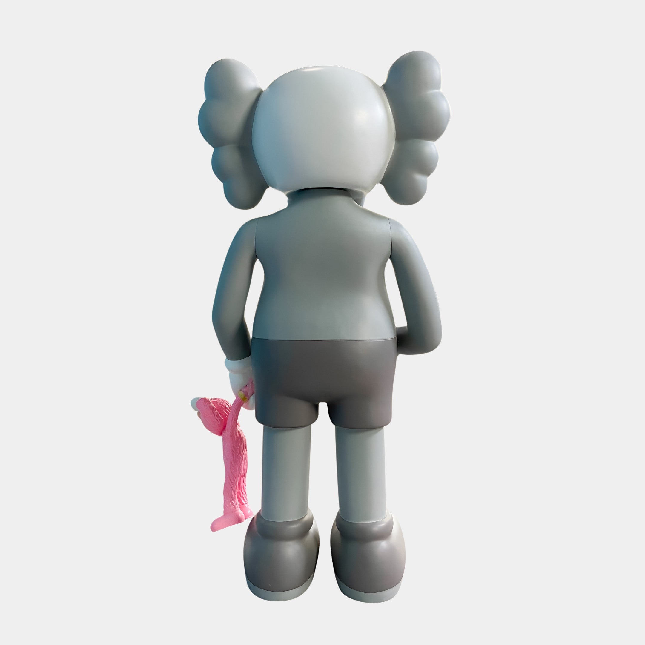 The Soft Grey Iconify Pink Furry Toy Figure - 28cm by Giant Sculptures features puffy ears, pink plush toy in hand, and shorts. Its smooth polyvinyl finish makes it ideal for modern décor.