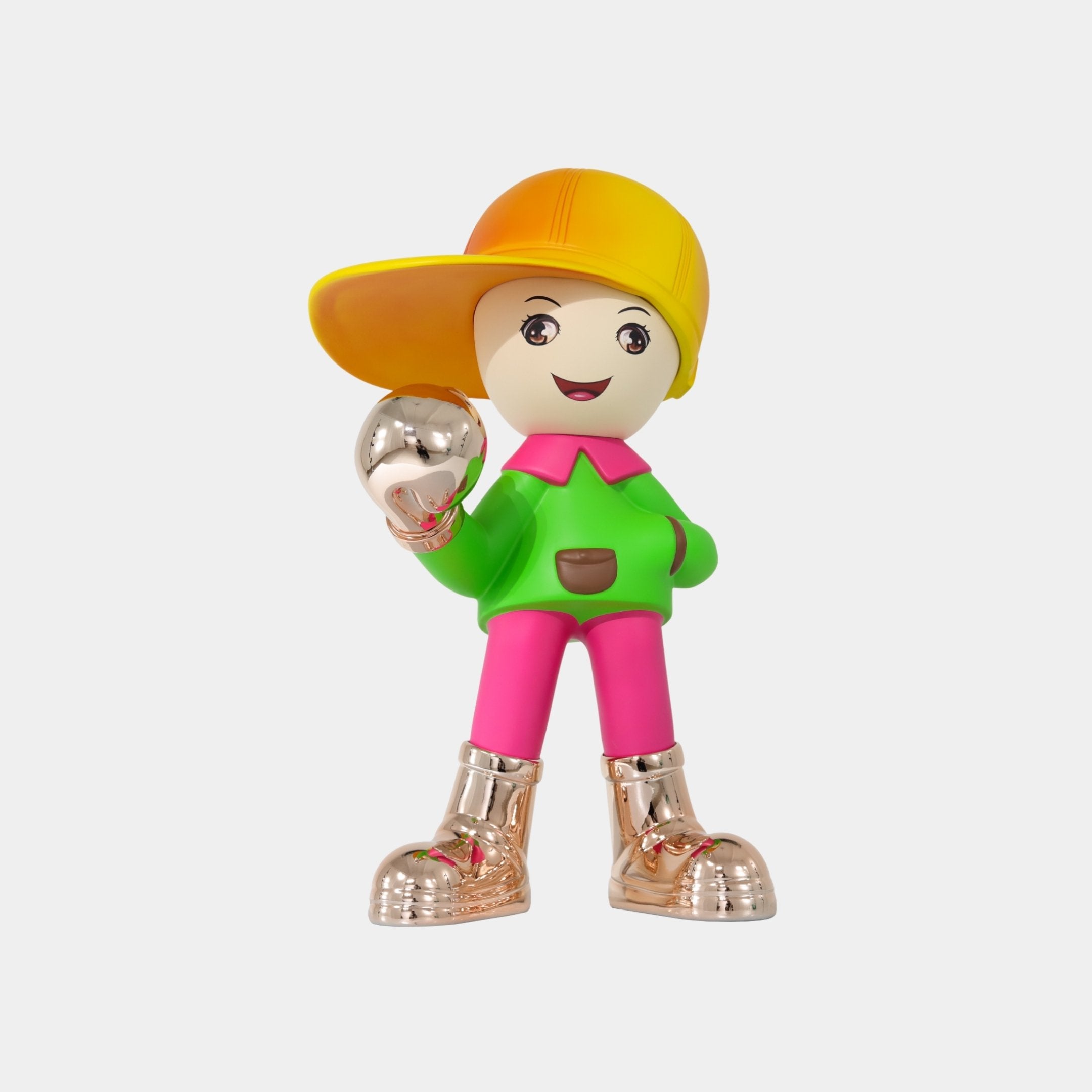 The Giant Sculptures Electroplated Boots & Fist Sunset Brimble Figure (52cm) features a decorative boy in a yellow cap, green shirt, and pink pants with metallic shoes, holding a silver ball and smiling against a white background.