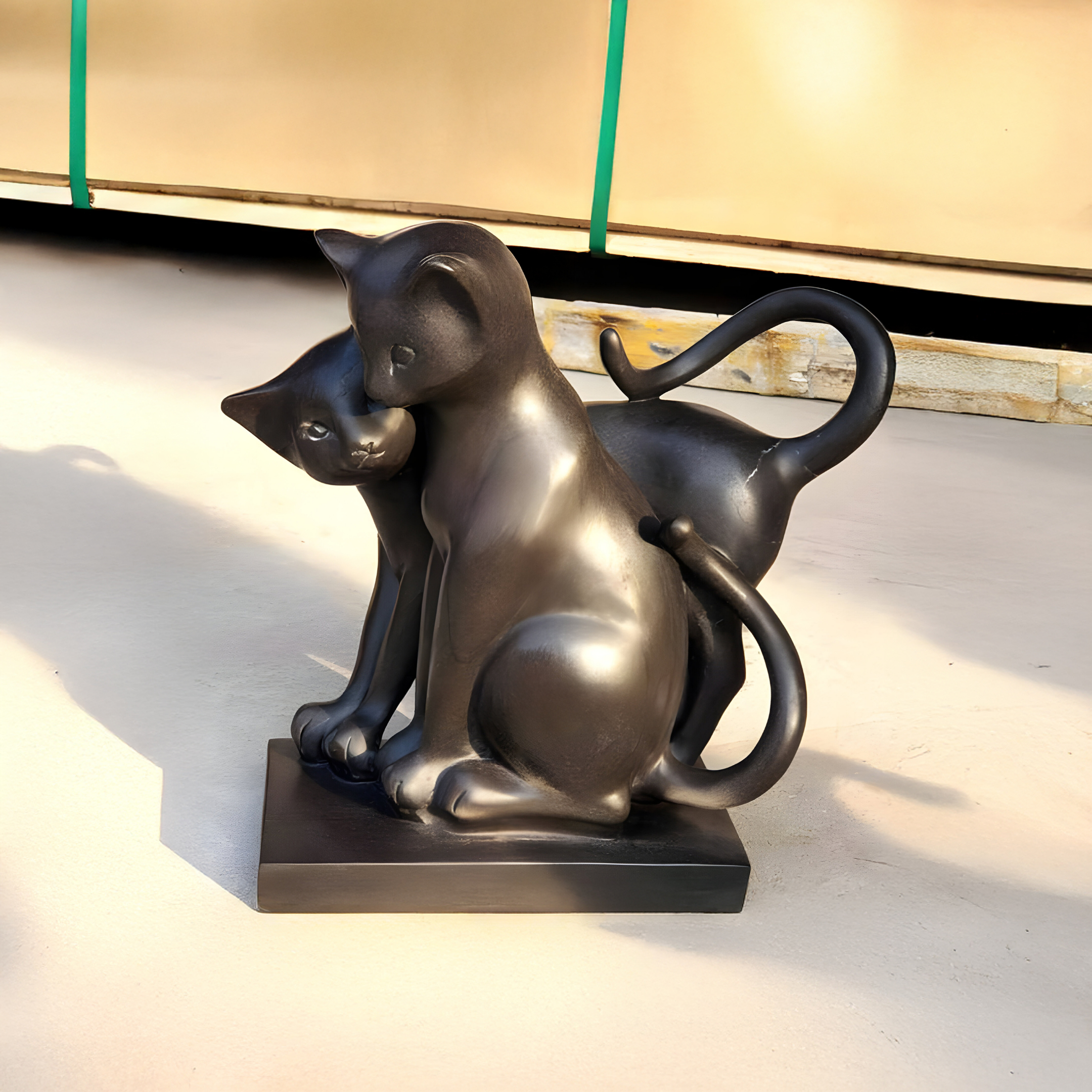 The Affectionate Cat Pair Marble Outdoor Sculpture by Giant Sculptures, standing 40cm tall, features two sleek cats—one sitting and the other leaning affectionately with gracefully curved tails—crafted elegantly in marble on a pedestal.
