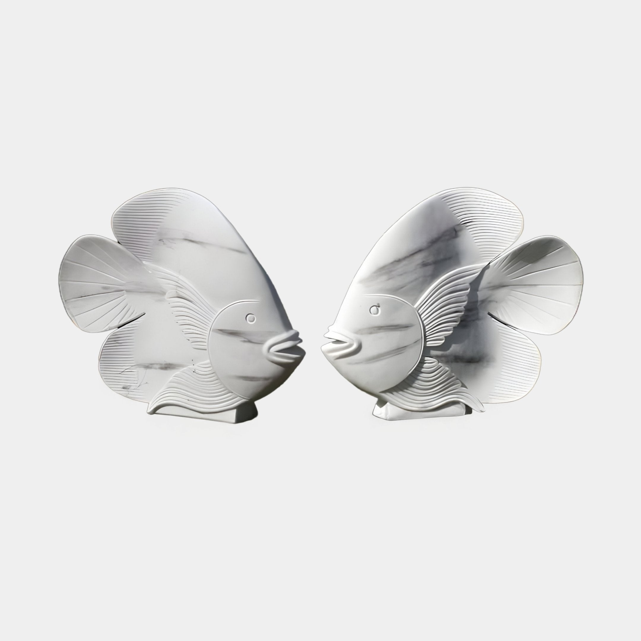 Swirl-Fin Angel Fish I Marble Outdoor Sculpture - 40cm by Giant Sculptures features two marble-like fish with sleek, curved lines that capture the essence of an elegant aquatic-themed design against a plain white background.