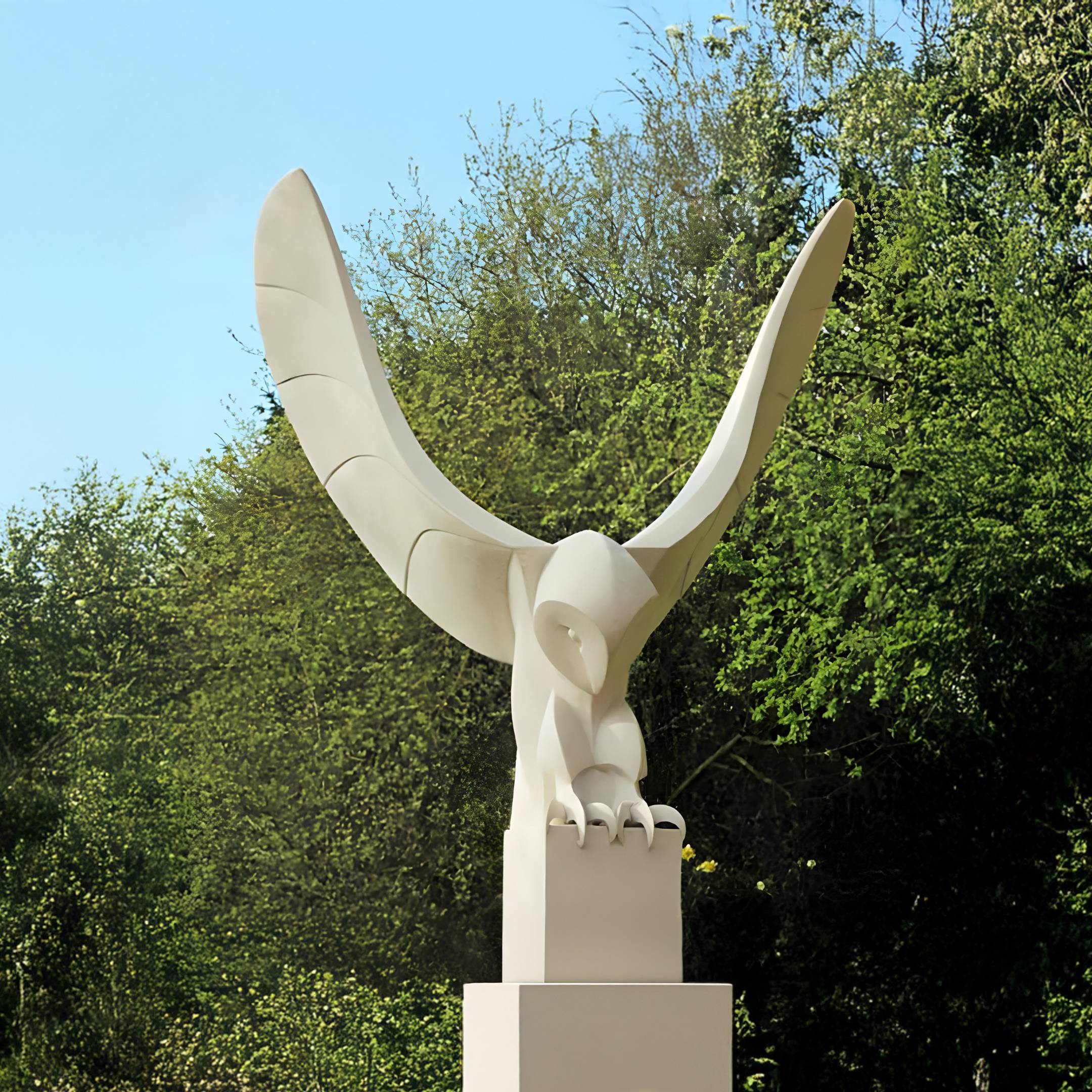 The Swooping Arc Large Owl Outdoor Sculpture by Giant Sculptures, standing 150cm tall in hand-carved marble, depicts a sleek owl in motion. It is displayed on a pedestal amidst lush greenery under the sky.