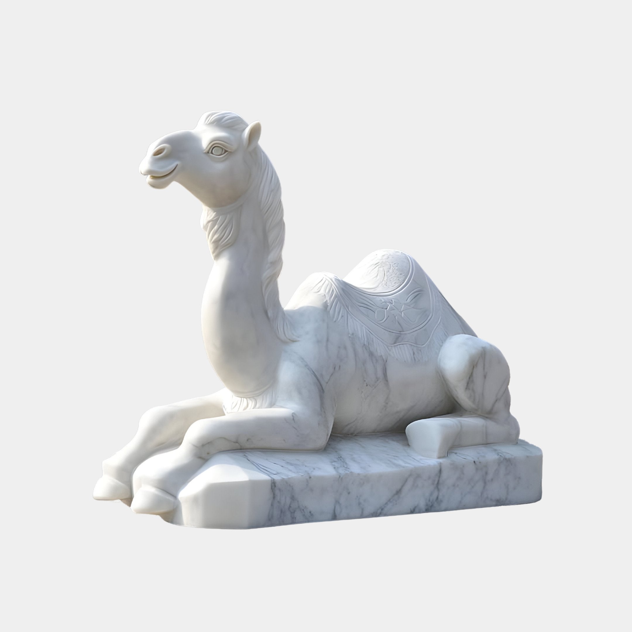 The Ornate Lying Camel Marble Outdoor Sculpture - 150cm by Giant Sculptures gracefully depicts a camel on a rectangular base, with detailed saddle and folded legs capturing desert heritage against a plain white backdrop.