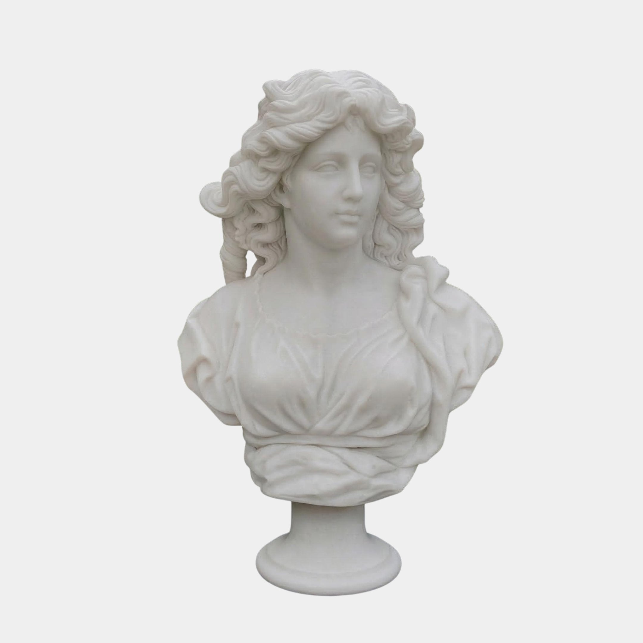 The Classical Female Marble Bust Sculpture - 65cm by Giant Sculptures features a woman with wavy hair and draped clothing, expertly crafted from natural white marble and showcased on a simple pedestal against a plain background.
