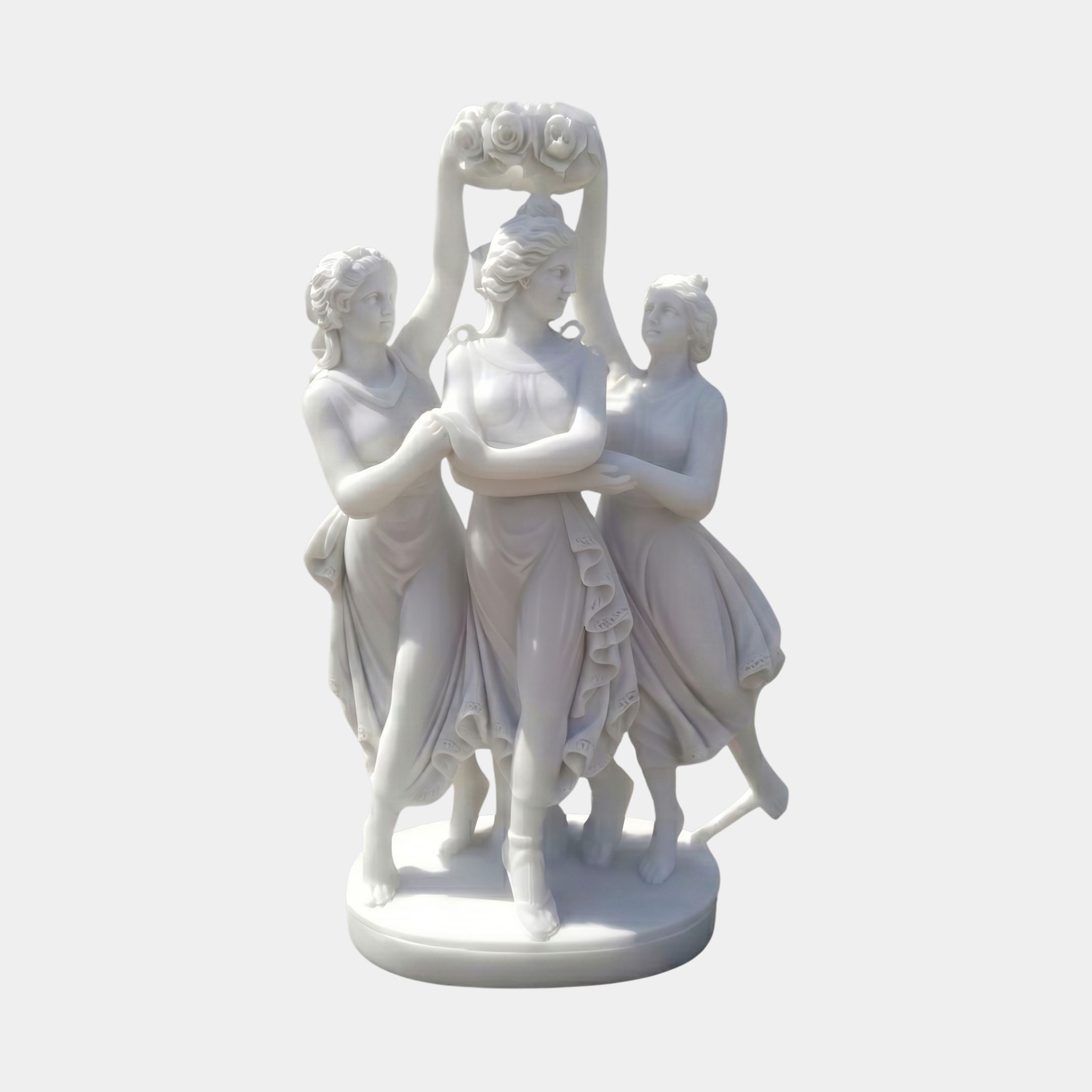 Three Dancing Women with Floral Wreath Marble Sculpture by Giant Sculptures, 100cm white marble group with central figure raising a floral wreath overhead.