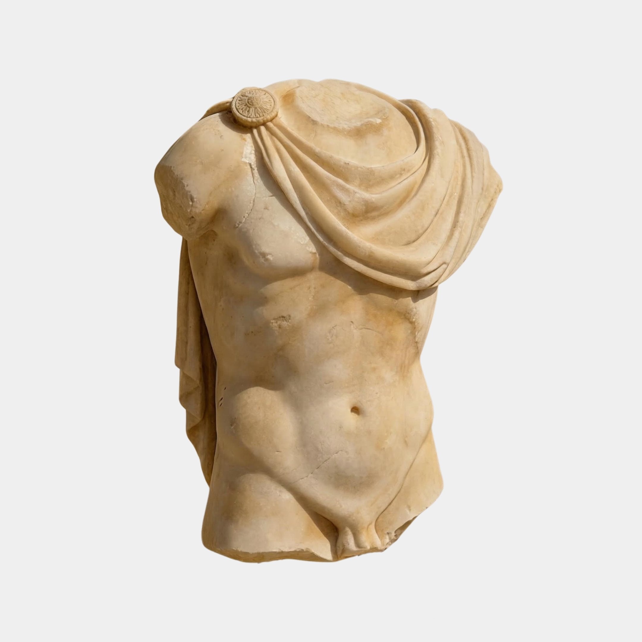 The Draped Marble Torso Sculpture - 120cm by Giant Sculptures features a classical male form with detailed musculature, missing head, arms, and legs, draped in cloth over one shoulder. Crafted in natural marble on a plain white background.