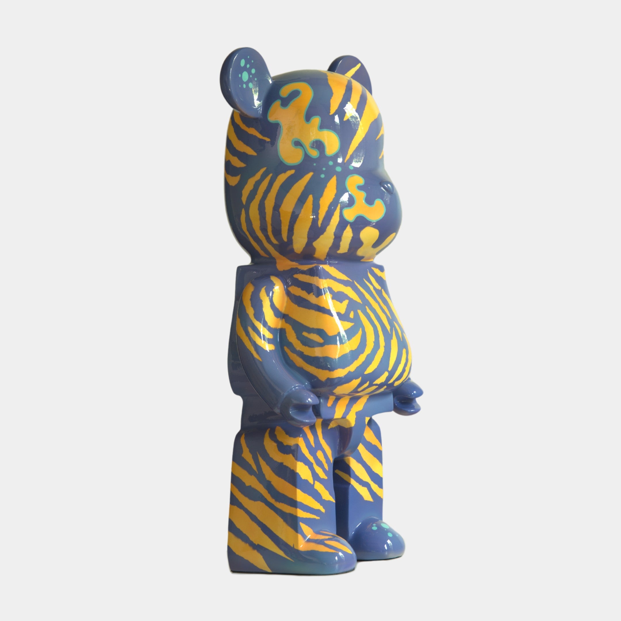 The Inside Appears Outside 2 Bear Sculpture (135cm) by Giant Sculptures features hand-painted swirling yellow and orange tiger stripes on a blue background, standing upright and facing slightly to the right.