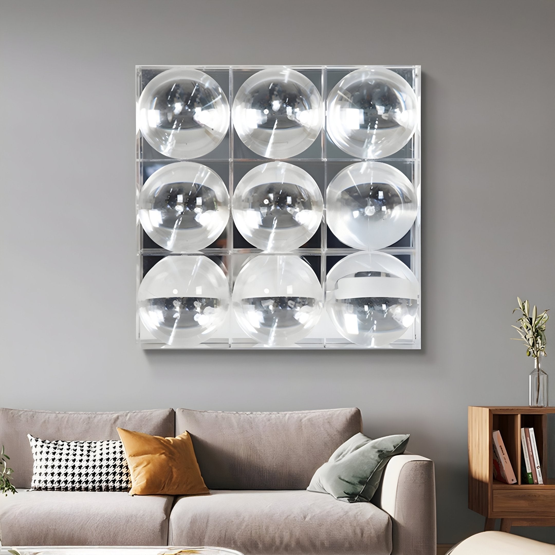 A modern living room with a light gray sofa, yellow and black accent pillows, and the Giant Sculptures Haloid I Bubble Grid Acrylic 3D Wall Art featuring nine clear spheres arranged in a square grid above the couch.