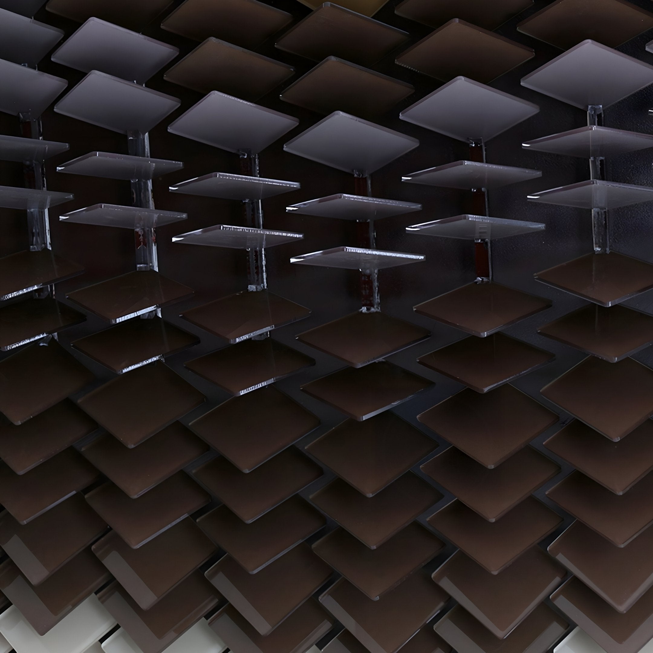Close-up of a ceiling or wall featuring Giant Sculptures Tessera Caramel & Walnut Gradient Acrylic 3D Wall Art, with dark, shiny panels arranged in a staggered pattern for a striking geometric and modern visual effect.