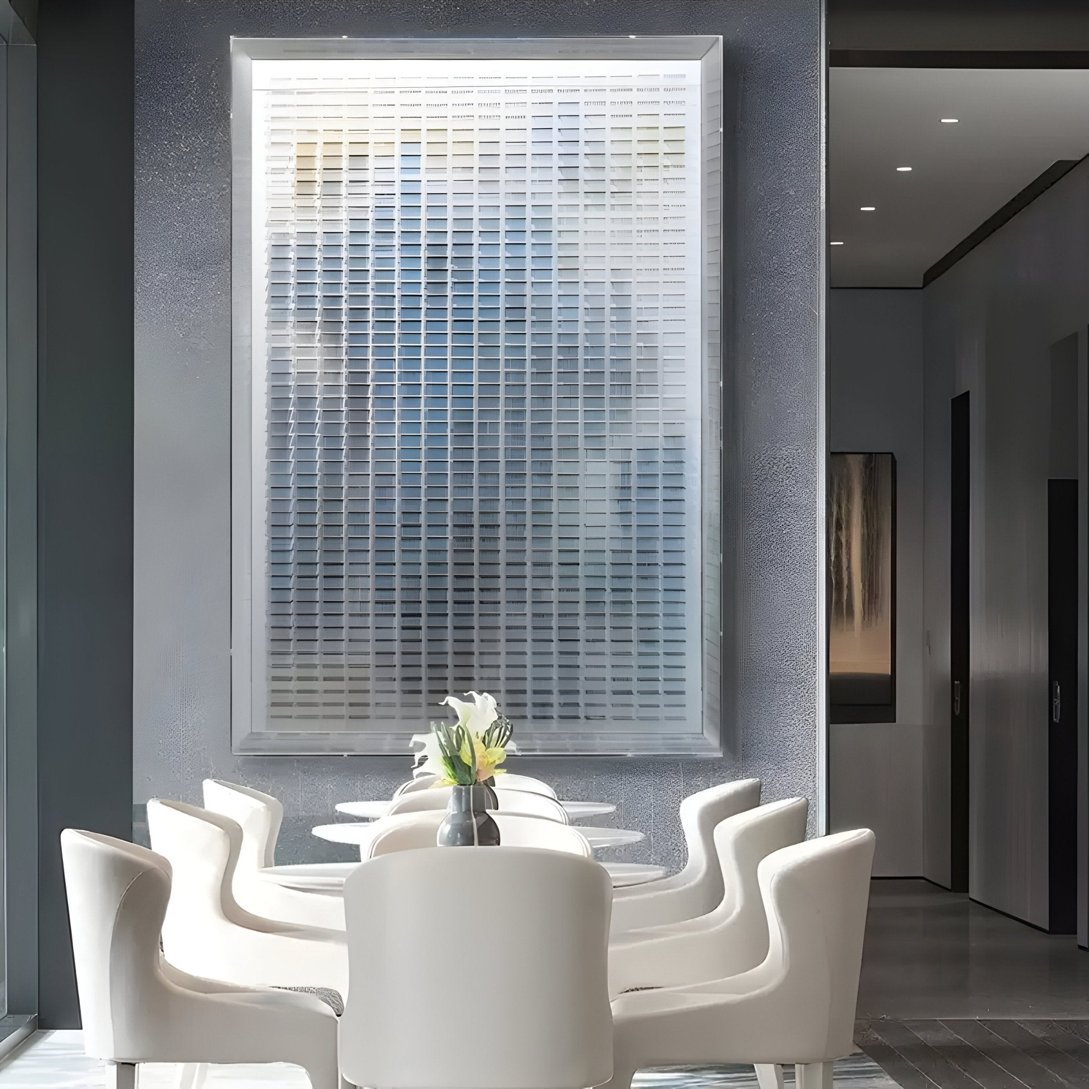 A bright, minimalist dining area with white chairs around a sleek table, a small flower vase, and the Chromat Nebula Blue Gradient Acrylic 3D Wall Art by Giant Sculptures adding contemporary style to the wall behind.