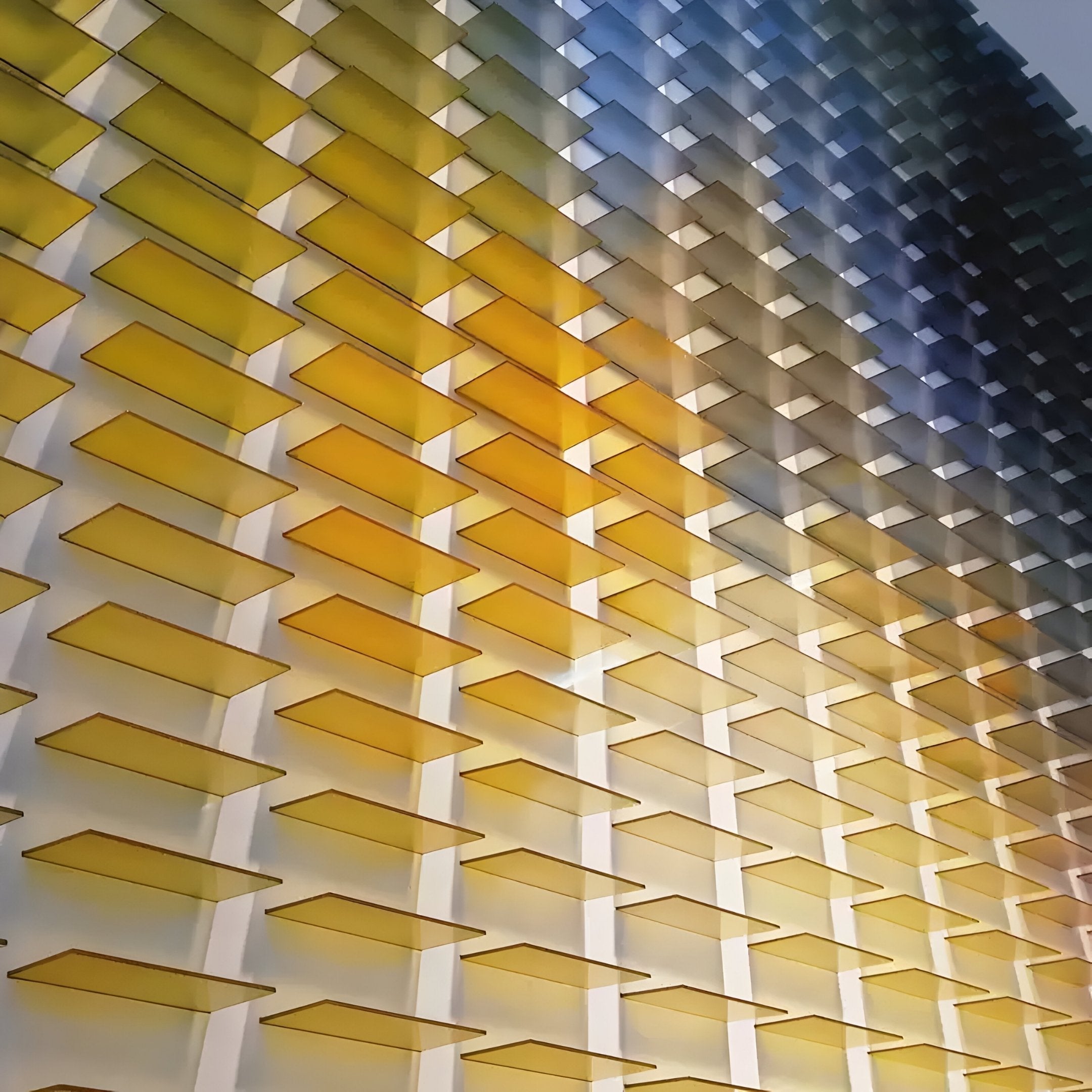 The Chromat Lemon Sky Radiance Acrylic 3D Wall Art by Giant Sculptures features yellow and blue rectangular panels, creating a geometric gradient from warm yellow at the bottom left to cool blue at the top right.