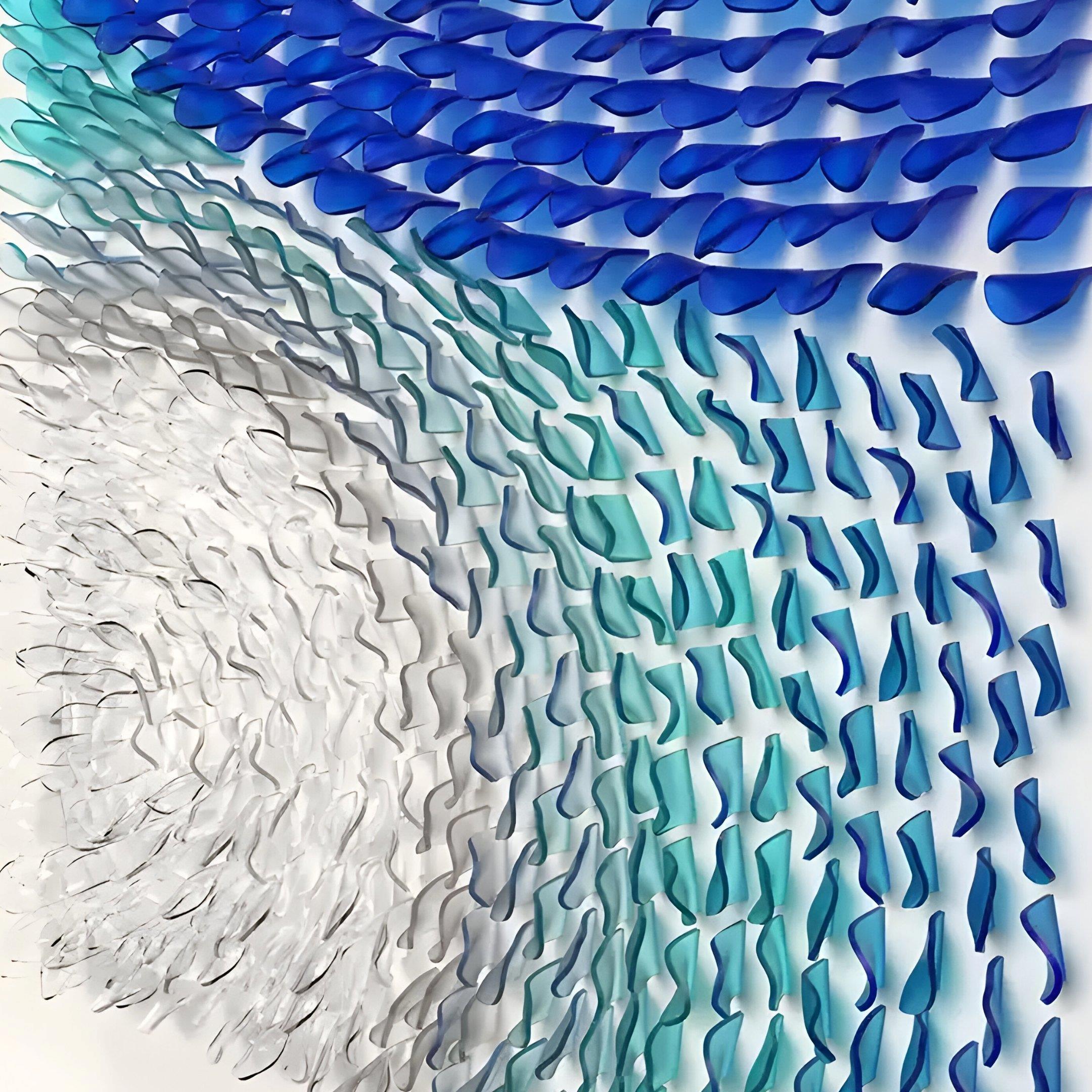 The Glaciera Ripple Blue Aqua Silver Acrylic 3D Wall Art by Giant Sculptures features curved, translucent forms in blue and teal with silver accents, arranged in dynamic, wave-like patterns to evoke movement and fluidity.
