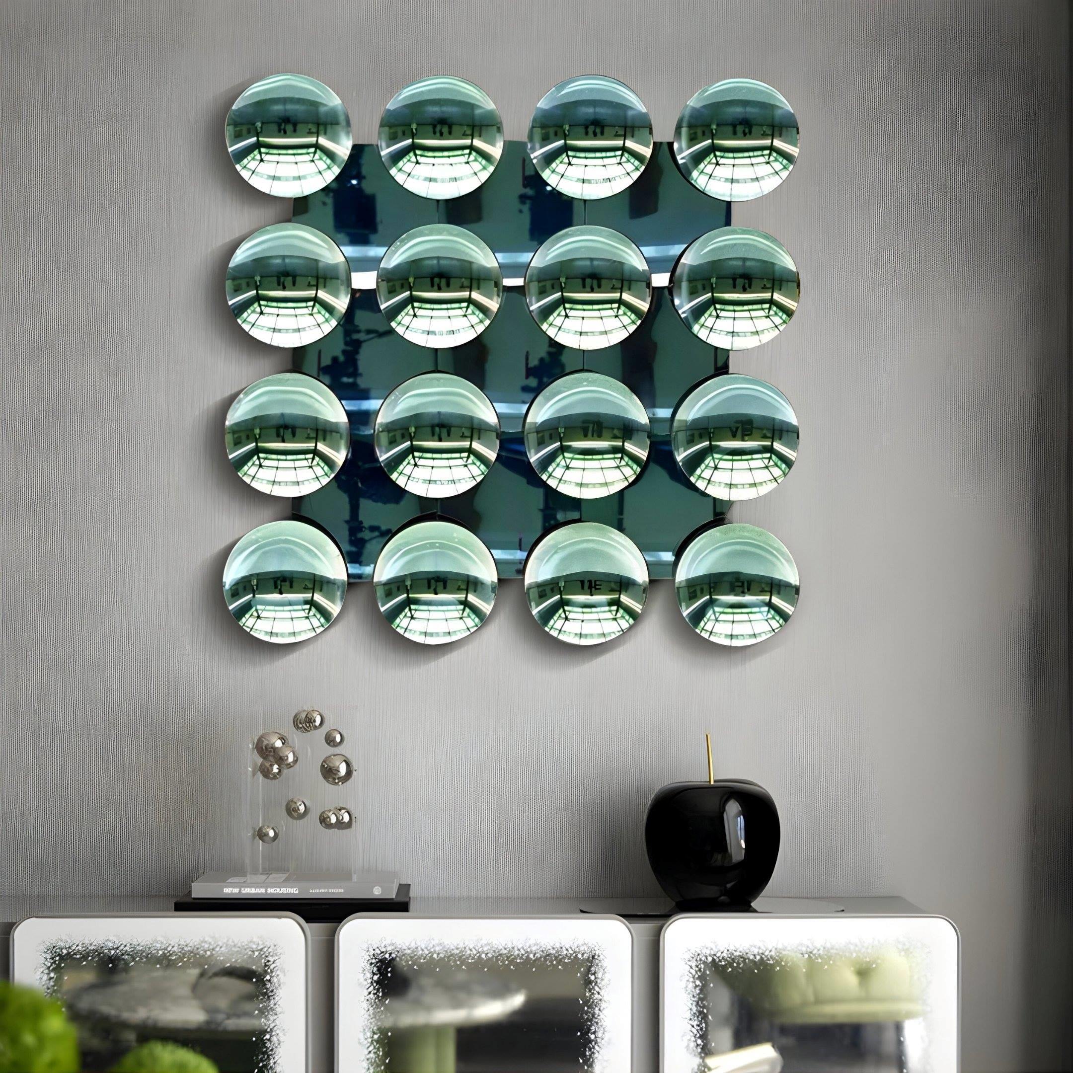 Sixteen Dome Emerald Green Acrylic 3D Wall Art pieces by Giant Sculptures, arranged in a 4x4 grid, create eye-catching modern wall décor above a white glass-door cabinet topped with an abstract sculpture and black vase.