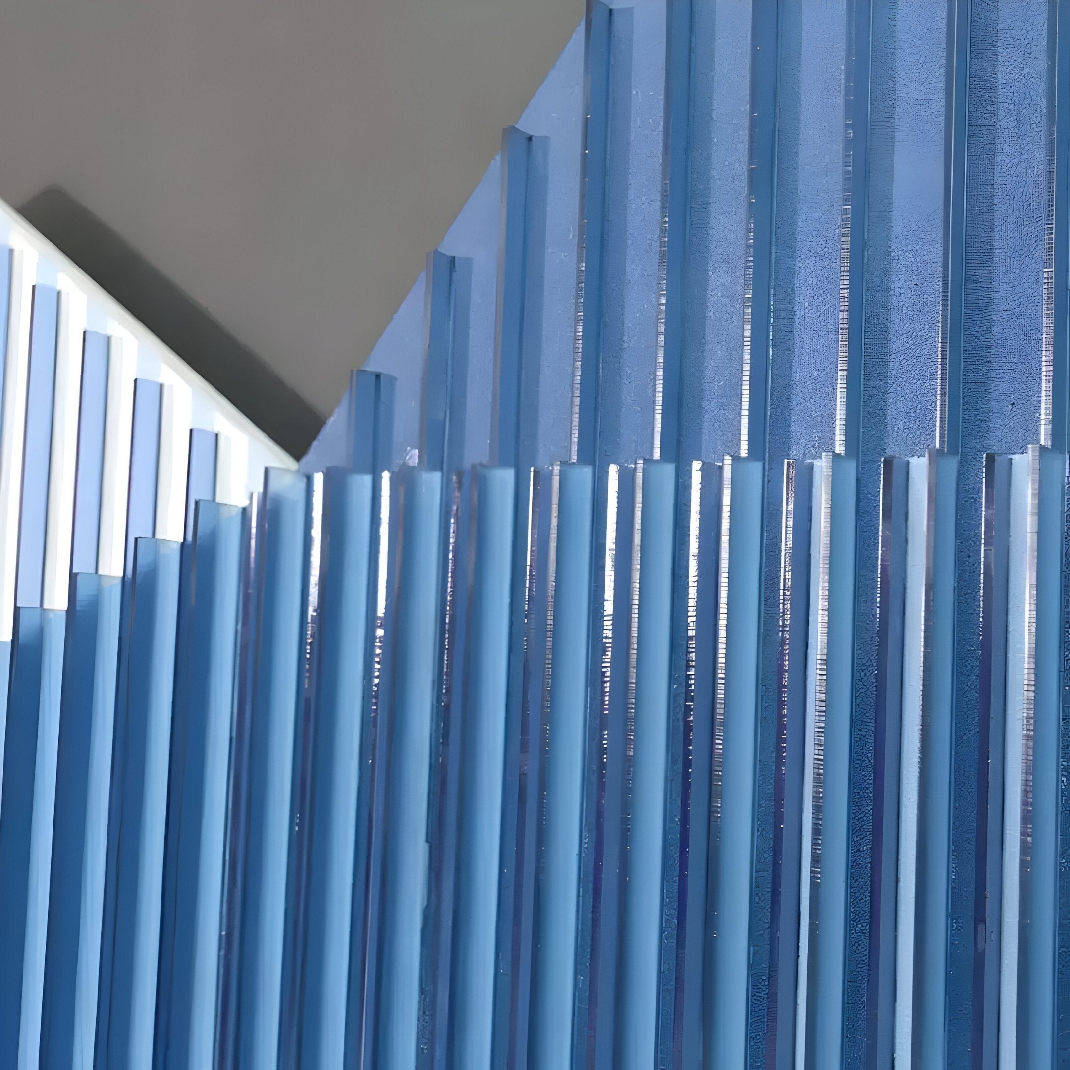 The Vertex Deep Navy & White Ridge Acrylic & Wood Carving 3D Wall Art by Giant Sculptures features blue and white ribbed panels arranged at varied angles, creating a bold geometric abstract pattern on a muted gray background.