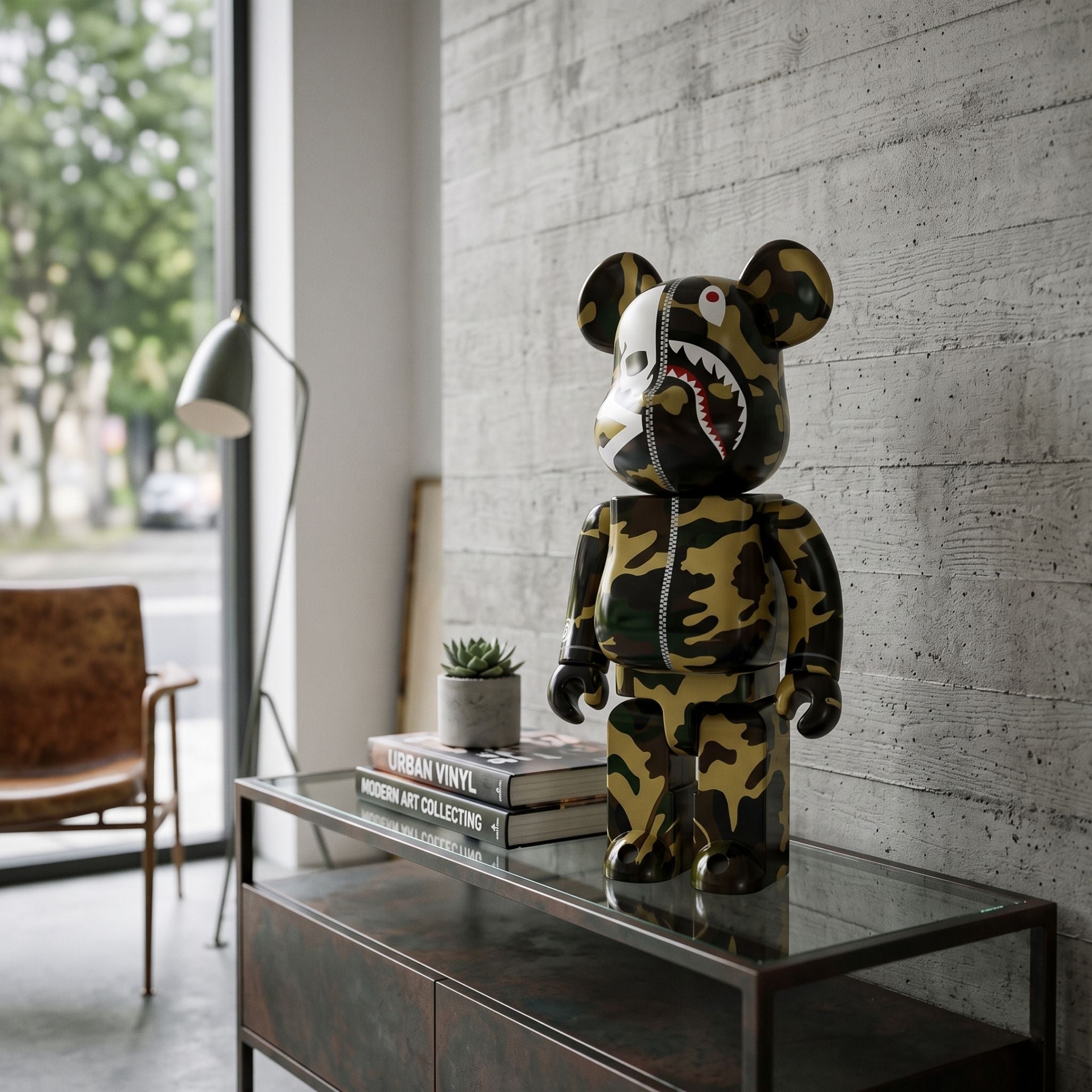 Apex Split Bear Sculpture - 70cm in camouflage resin with shark-face graphic and centre zipper, displayed on a console table beside books and a plant in a modern living space.