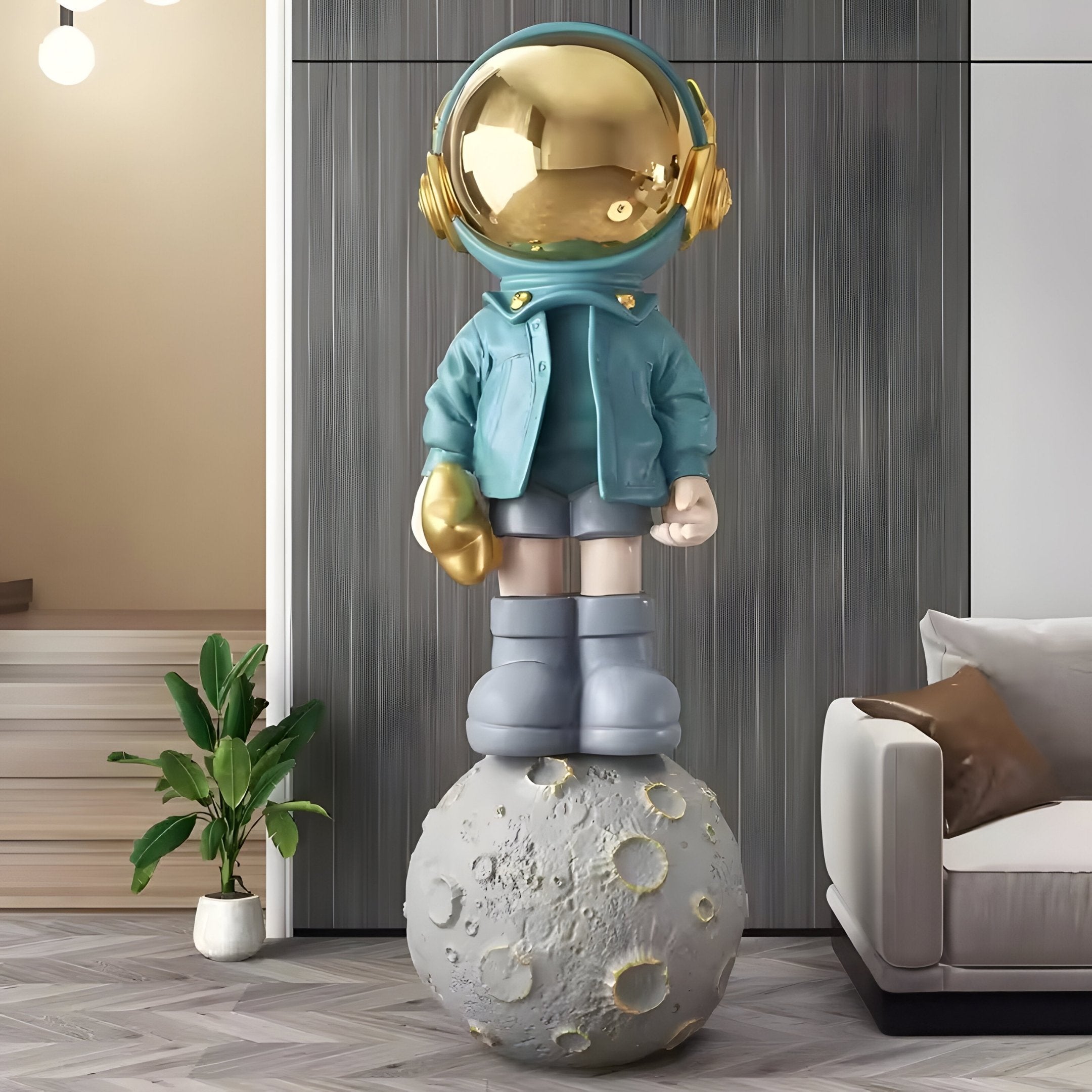 The Galactic Blue Astronaut Beats On Moon Sculpture (210cm) by Giant Sculptures features a whimsical, childlike figure with a gold helmet and blue jacket, perfect for adding charm to modern spaces near plants or a beige sofa.