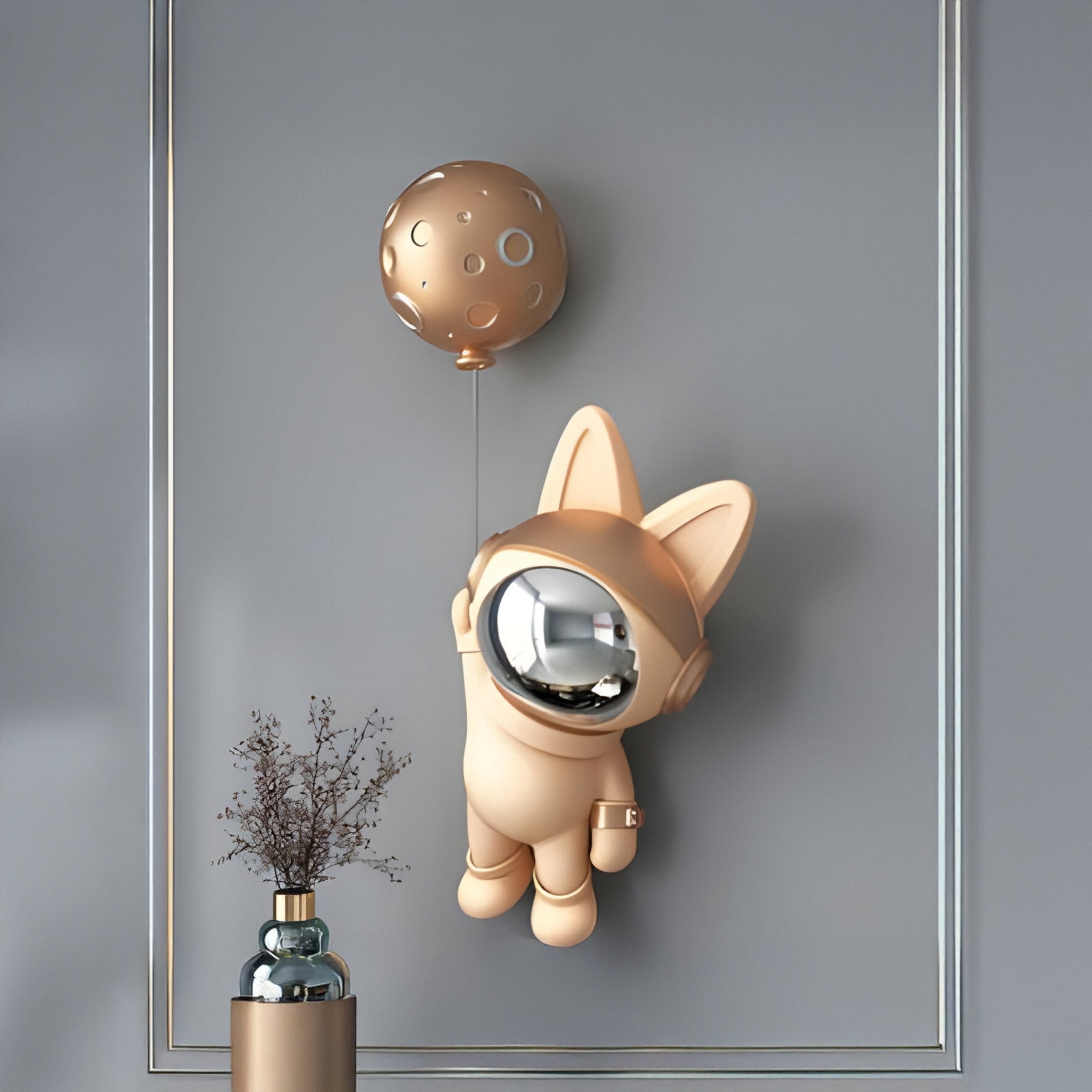 The Giant Sculptures Rose Gold Astronaut Bunny Balloon 3D Wall Art (70cm) is displayed above a modern vase on a gray wall, its gold moon-shaped balloon adding cosmic flair to this minimalist, contemporary space.