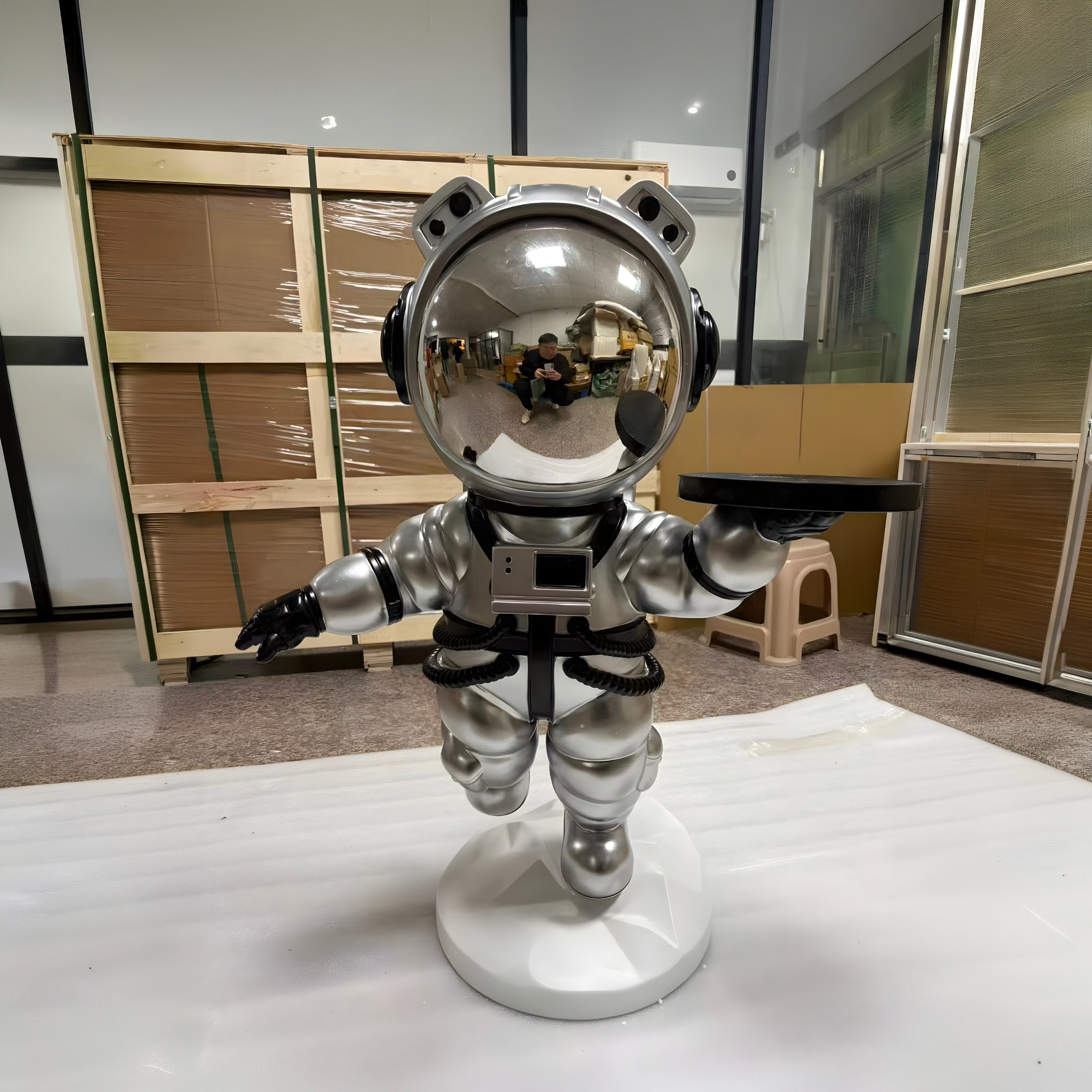 The Astral Silver Astronaut Bear Butler Sculpture (90cm) by Giant Sculptures stands on a round base holding a black tray. Its reflective visor adds futuristic charm, making it the perfect space-themed accent for your home.