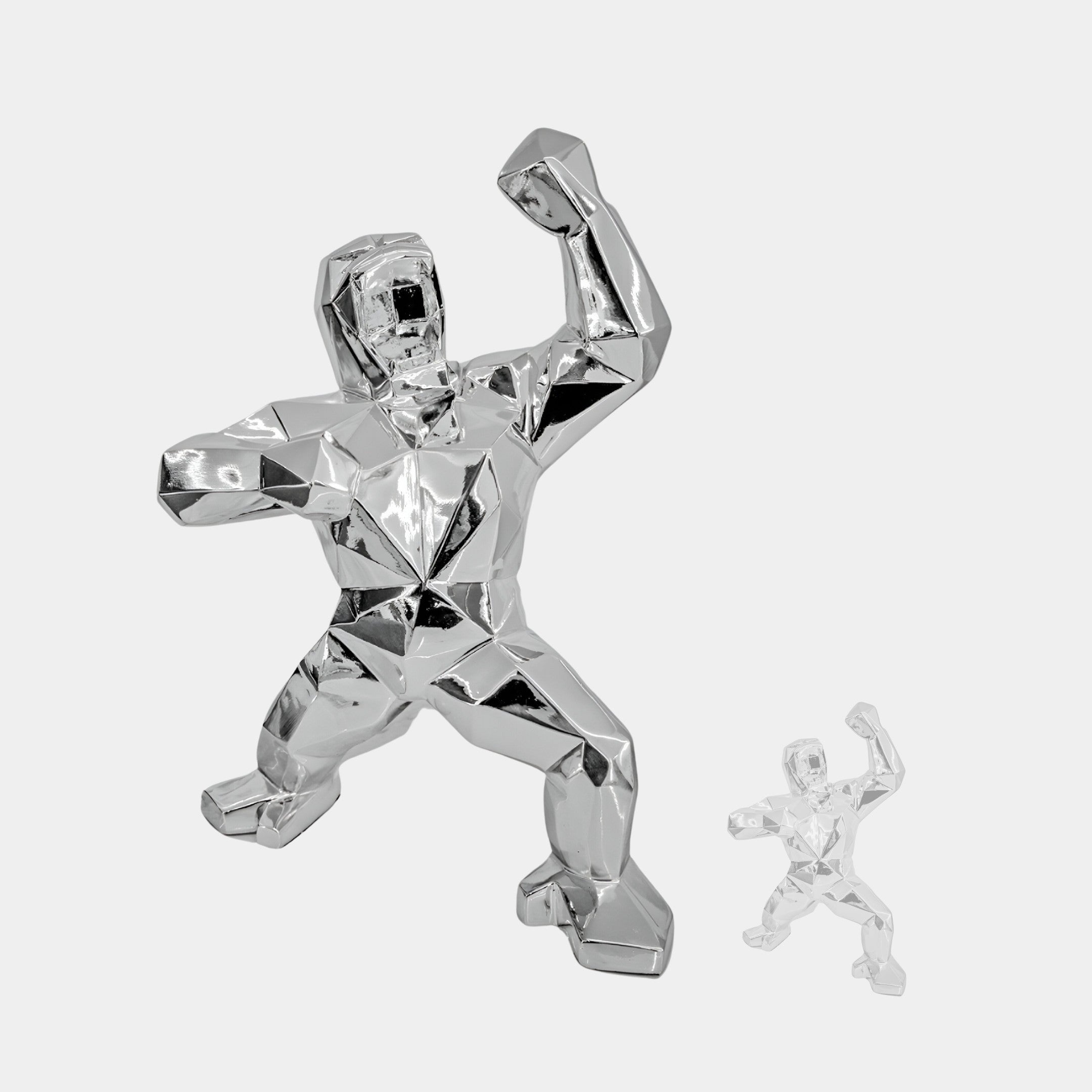 The Stellar Chrome Gorilla Sculpture - 165cm by Giant Sculptures, with its raised arm and angular design, stands alongside a smaller clear version against a white background. These modern art pieces feature faceted surfaces and dynamic poses, embodying strength and movement.