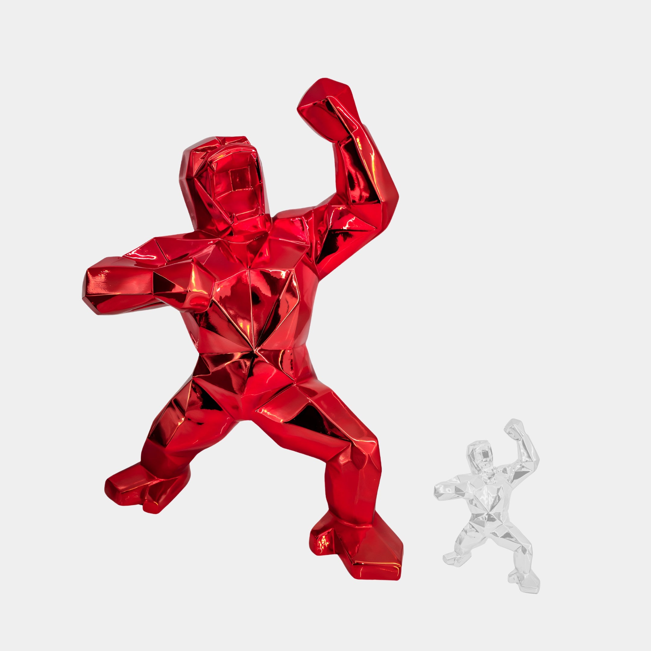 The Fire Red Gorilla Sculpture - 165cm from Giant Sculptures, with its bold, faceted design, powerfully complements a smaller clear version. Ideal for contemporary interiors, this duo stands out against a plain white background as an indoor statement piece.