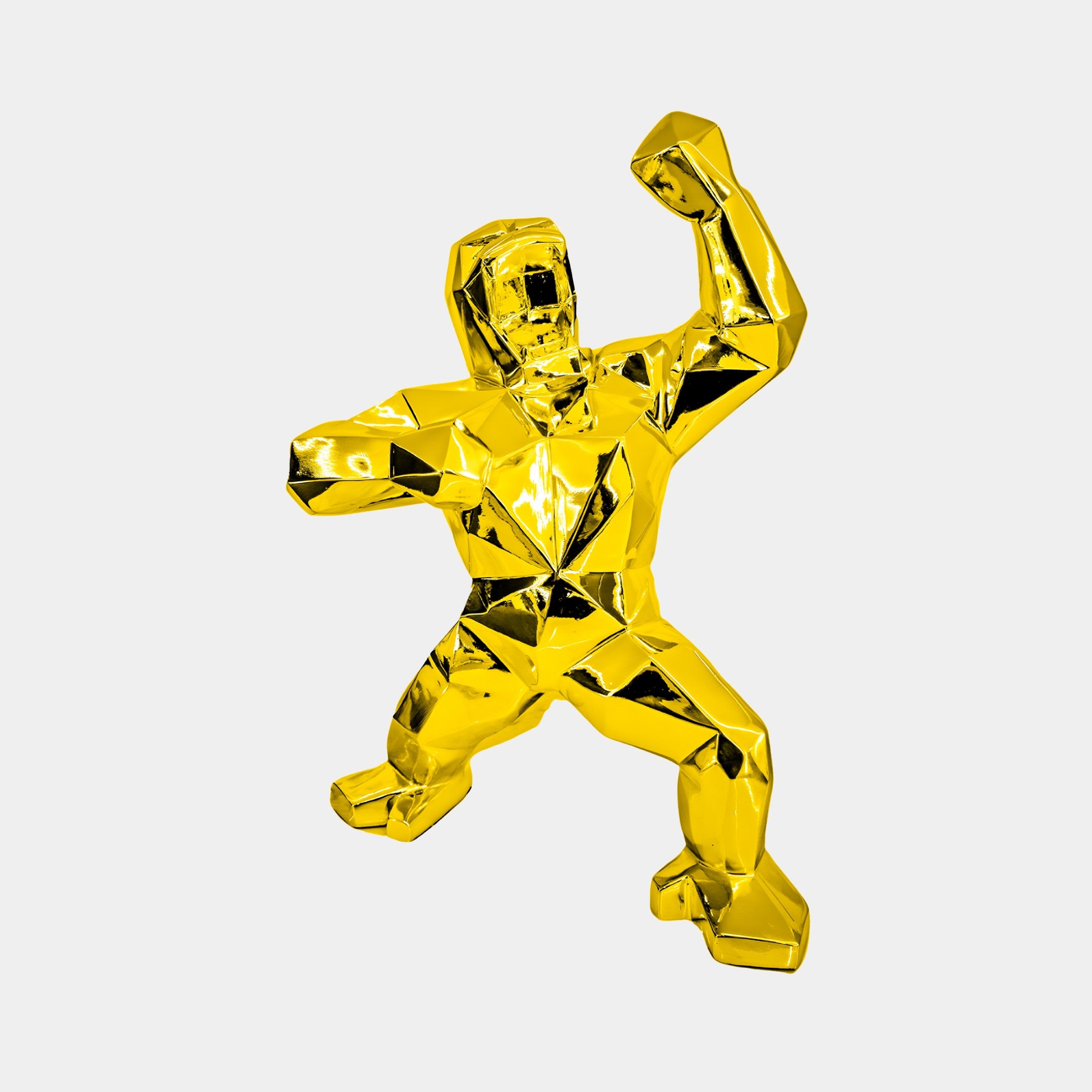 The Gilded Gold Gorilla Sculpture by Giant Sculptures is an exquisite luxury decor piece. This 50cm angular figure features faceted surfaces that enhance its elegance as it poses dynamically, raising one arm and stepping forward against a plain white background.