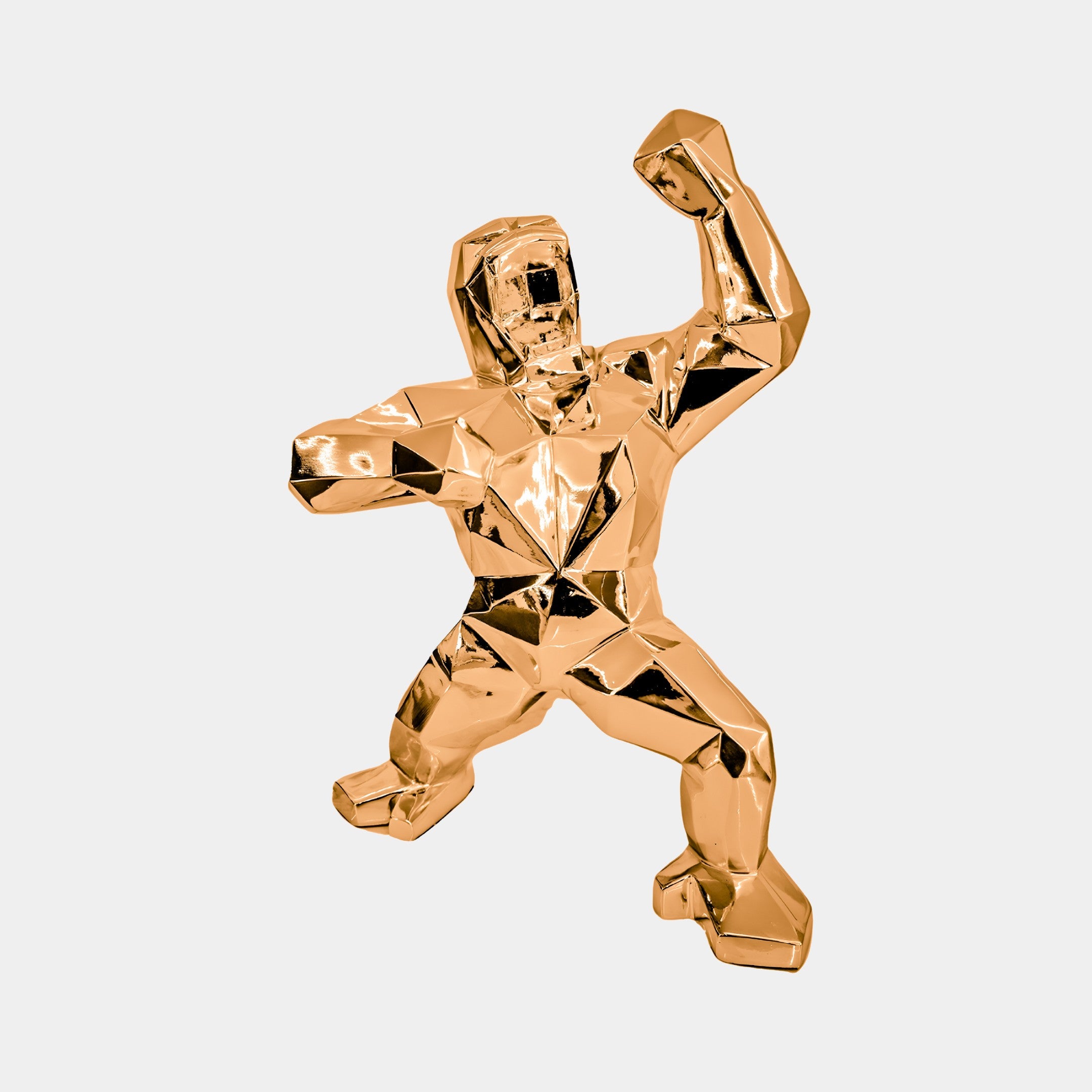 The Rose Gold Gorilla Sculpture - 50cm by Giant Sculptures is a shiny metallic masterpiece. This abstract piece features geometric facets and a stylized human-like form. With one arm raised, it sits against a plain background, serving as a modern centerpiece.