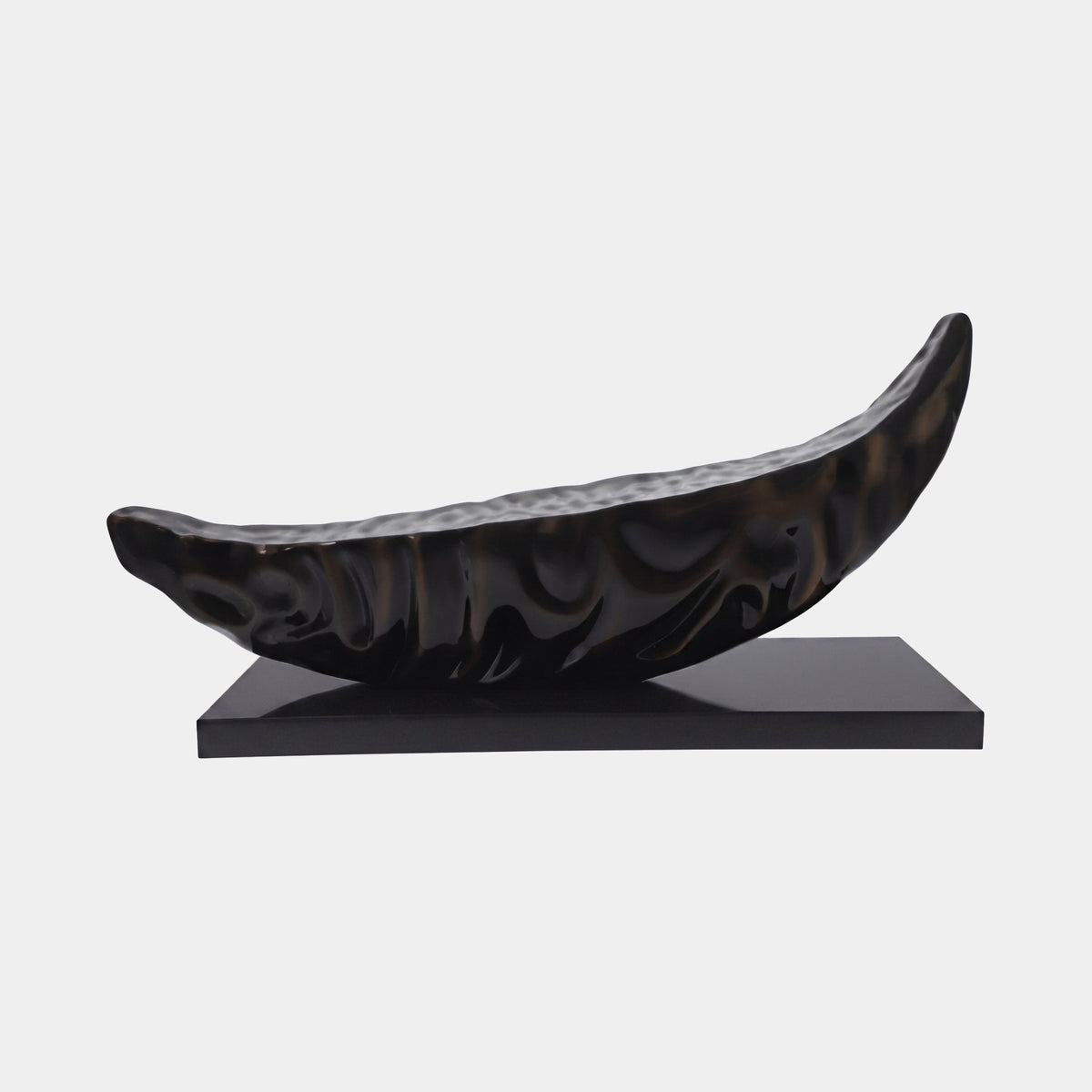 Brookgate Black Abstract Sculpture - 140cm, a glossy black fibreglass boat-dish form with curved tapered ends, mounted on a black rectangular base against a plain white background.