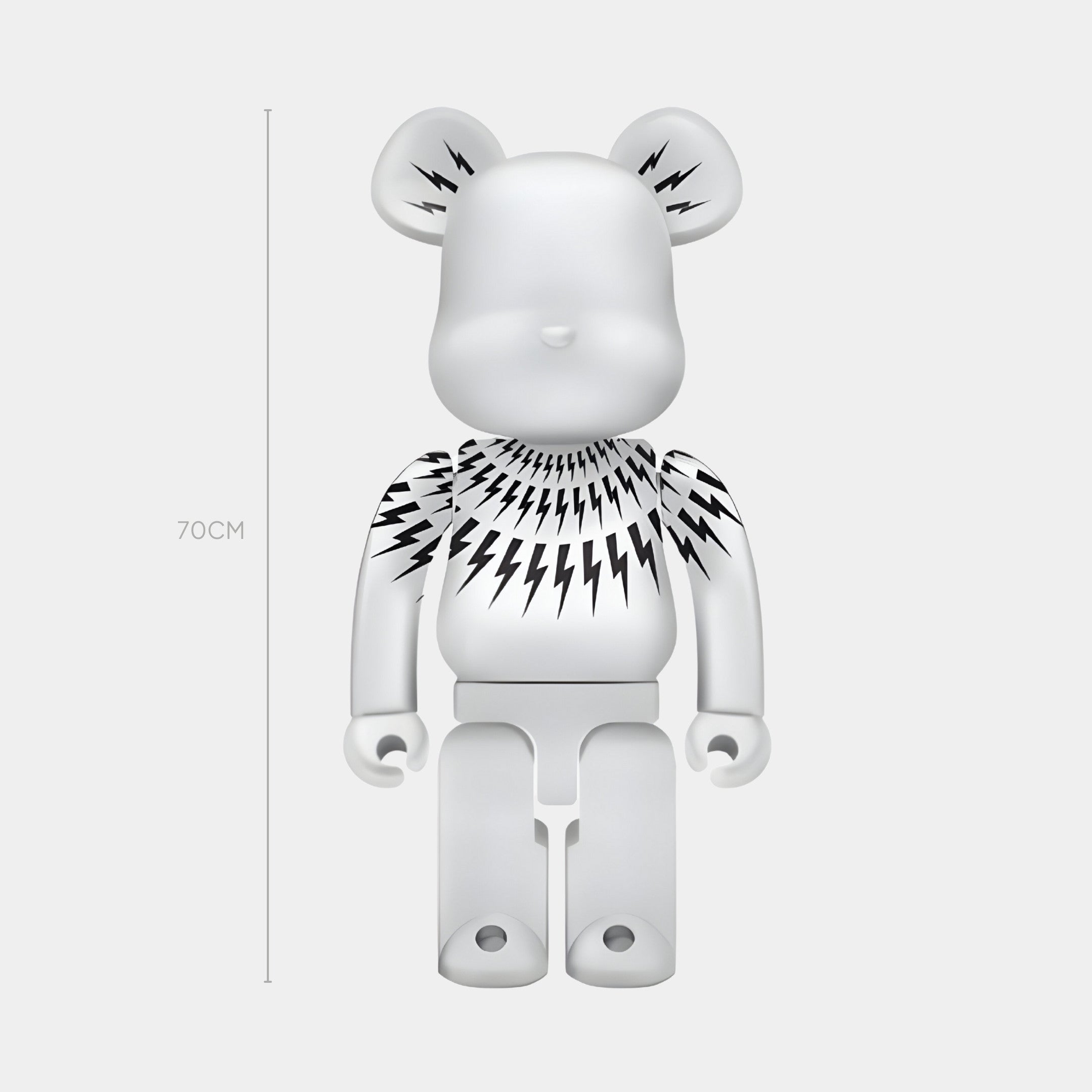 The Bolt Collar White Bear Sculpture by Giant Sculptures stands 70cm tall, featuring black lightning bolt designs on white—an ideal piece of modern interior decor. Displayed against a plain light backdrop.