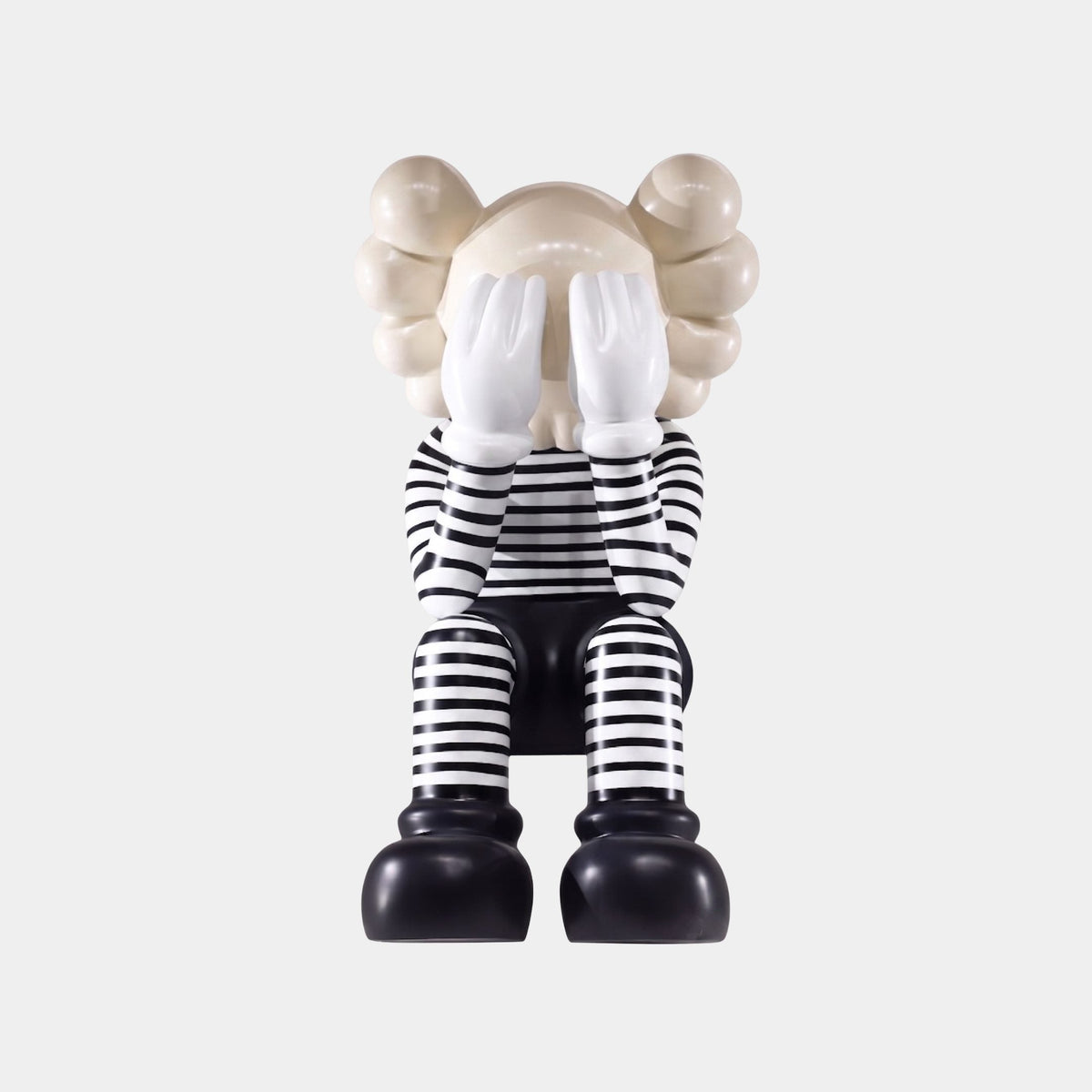 Norcombe Black & White Figure Sculpture (93cm) by Giant Sculptures, seated figure covering eyes with hands, striped black and white fibreglass finish, on plain white background.