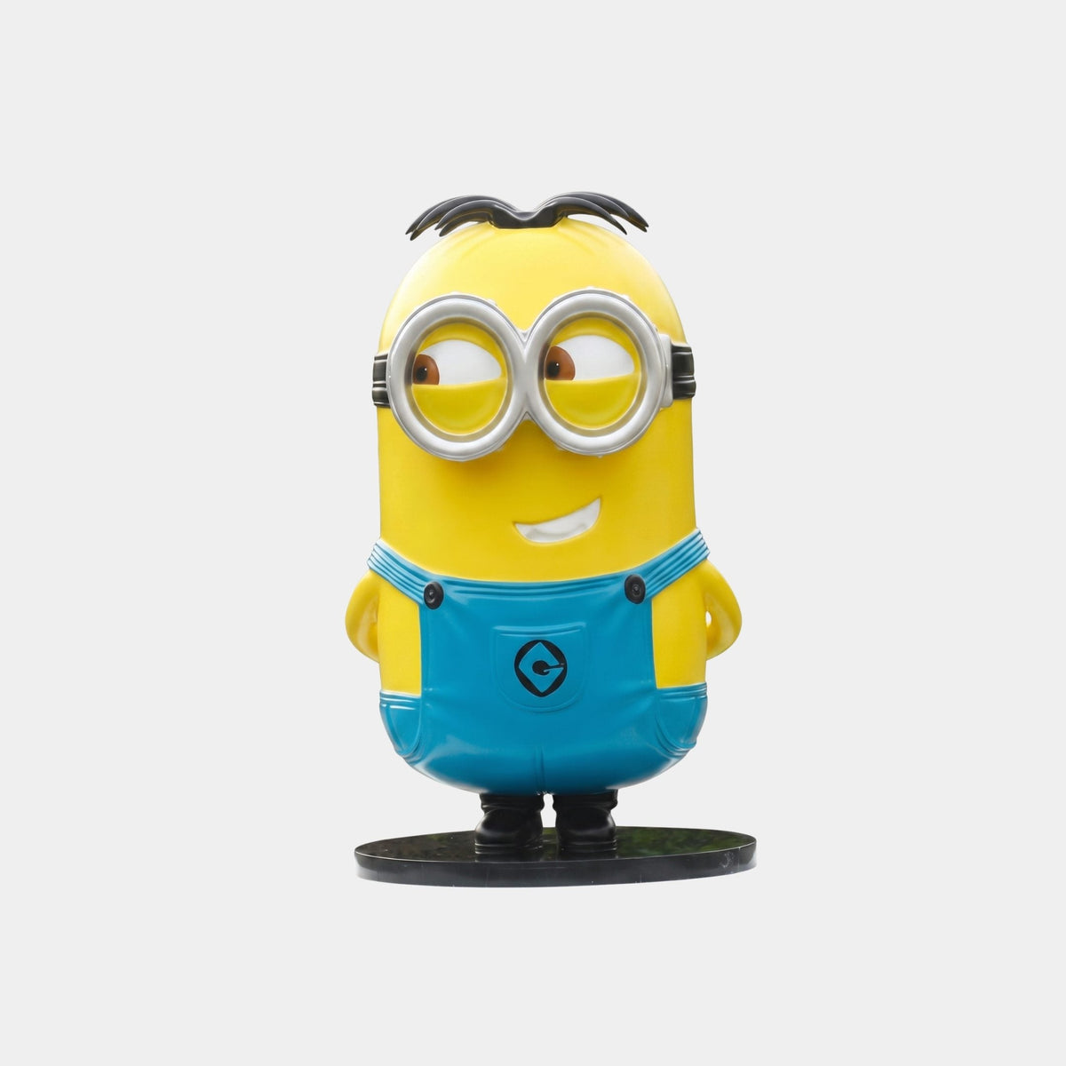 Oakwick Yellow Character Figure - 135cm fibreglass sculpture with goggles and blue overalls, standing on a black base against a plain light background.