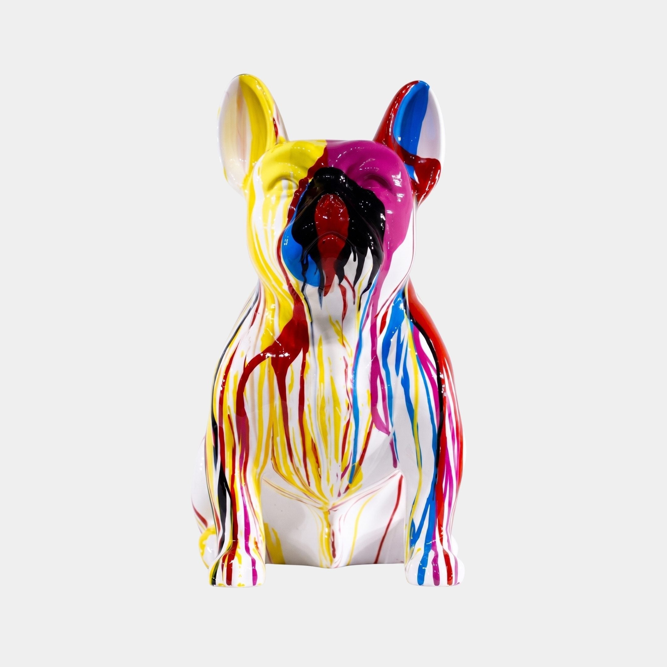 Sitting French Bulldog sculpture in glossy white finish with colorful dripping paint accents in yellow, red, blue, magenta, and black, shown against a plain light grey background.