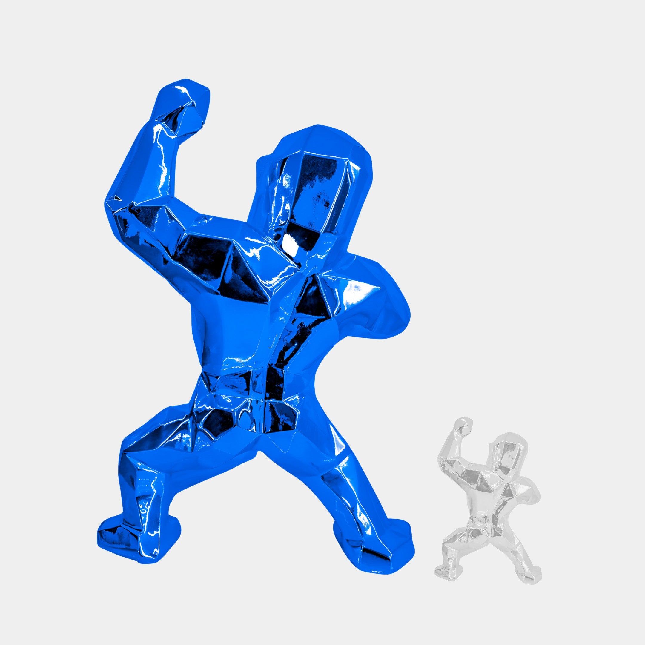 Two faceted indoor sculptures depict a blocky human figure in a dynamic pose with one arm raised. The larger, the Sapphire Blue Gorilla Sculpture by Giant Sculptures, features an electroplated finish, while the smaller remains clear and transparent, both against a plain white background.