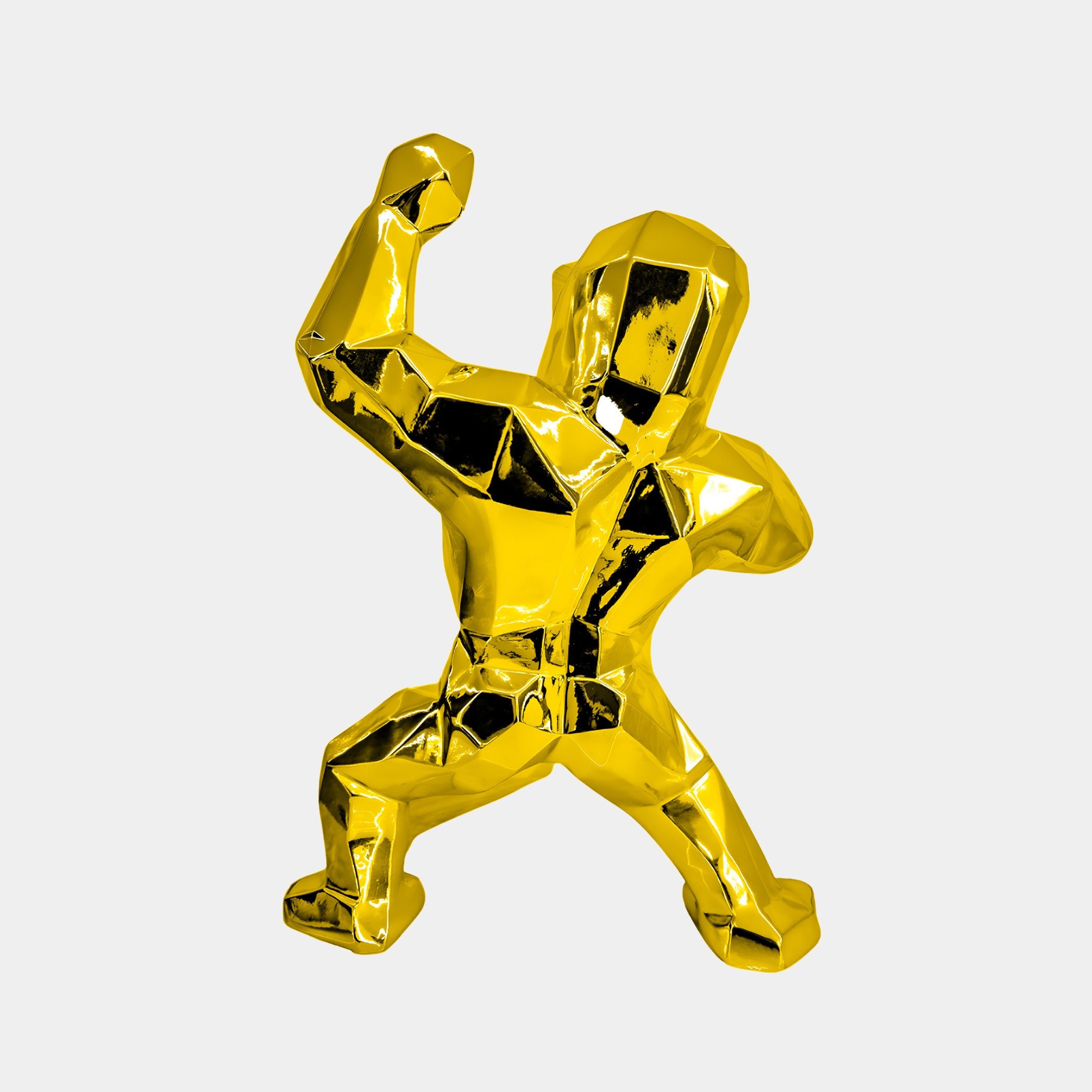 The Gilded Gold Gorilla Sculpture by Giant Sculptures is a 50cm shiny, geometric art piece. Exuding elegance with its gold-colored finish, it features a dynamic pose with one arm raised against a white background, ideal for luxury interior decor.
