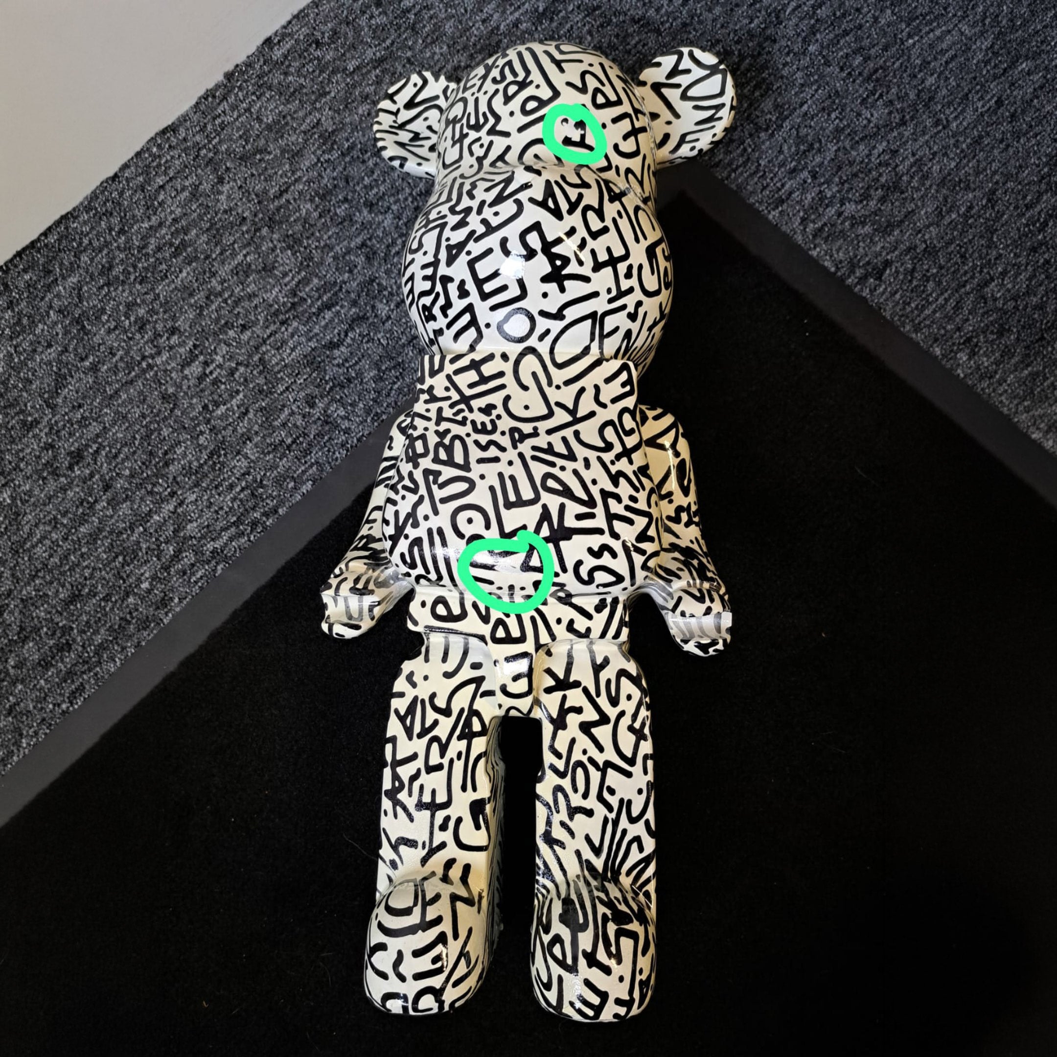 The Scribble Bear Sculpture - 50cm (Ex-Display) by Giant Sculptures features black graffiti-style lettering and green hearts on its eye and chest, making this limited edition piece a bold example of contemporary art.
