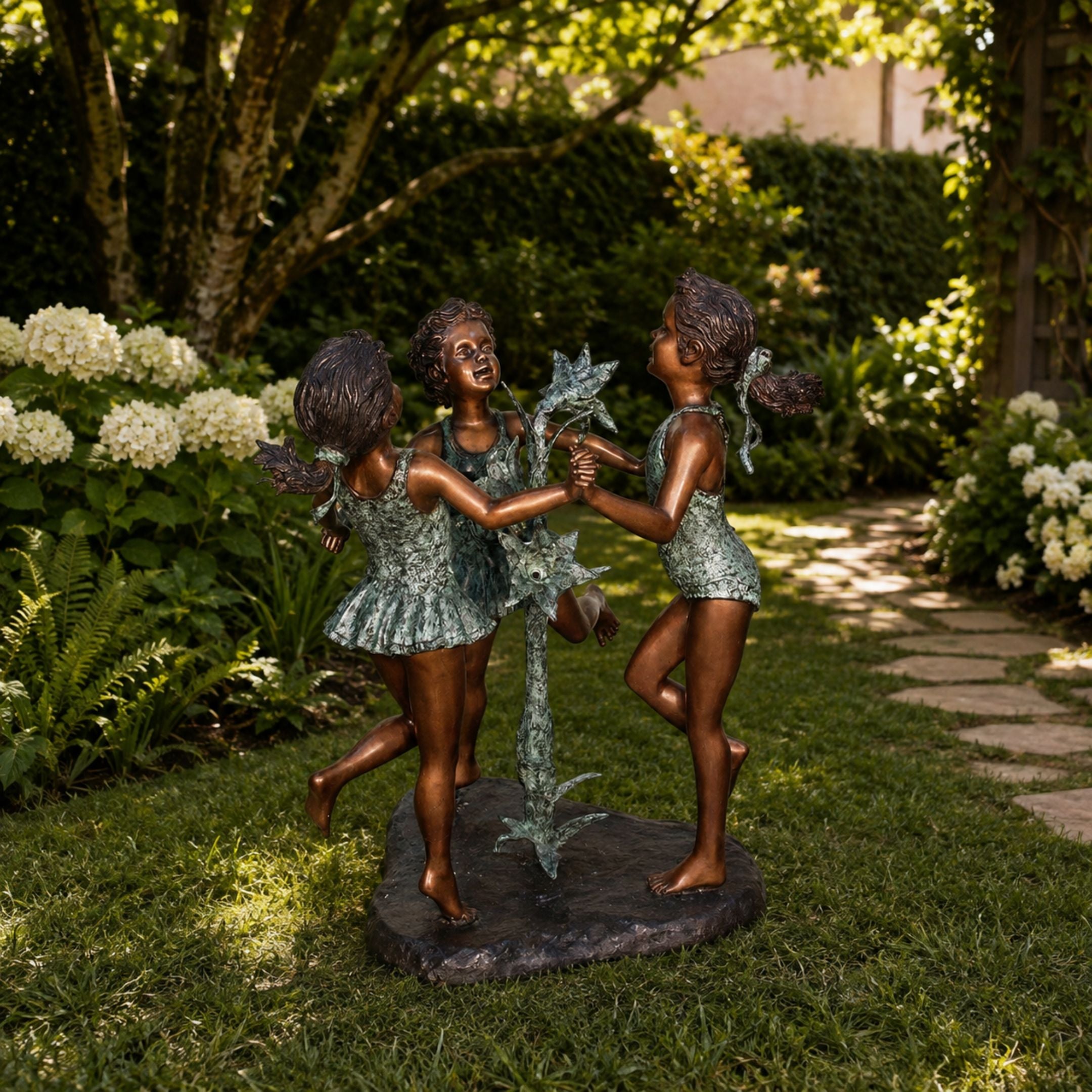 Large Traditional Dancing Girls Bronze Sculpture, 150cm, three barefoot girls circling a flower stem, set in a garden lawn setting.