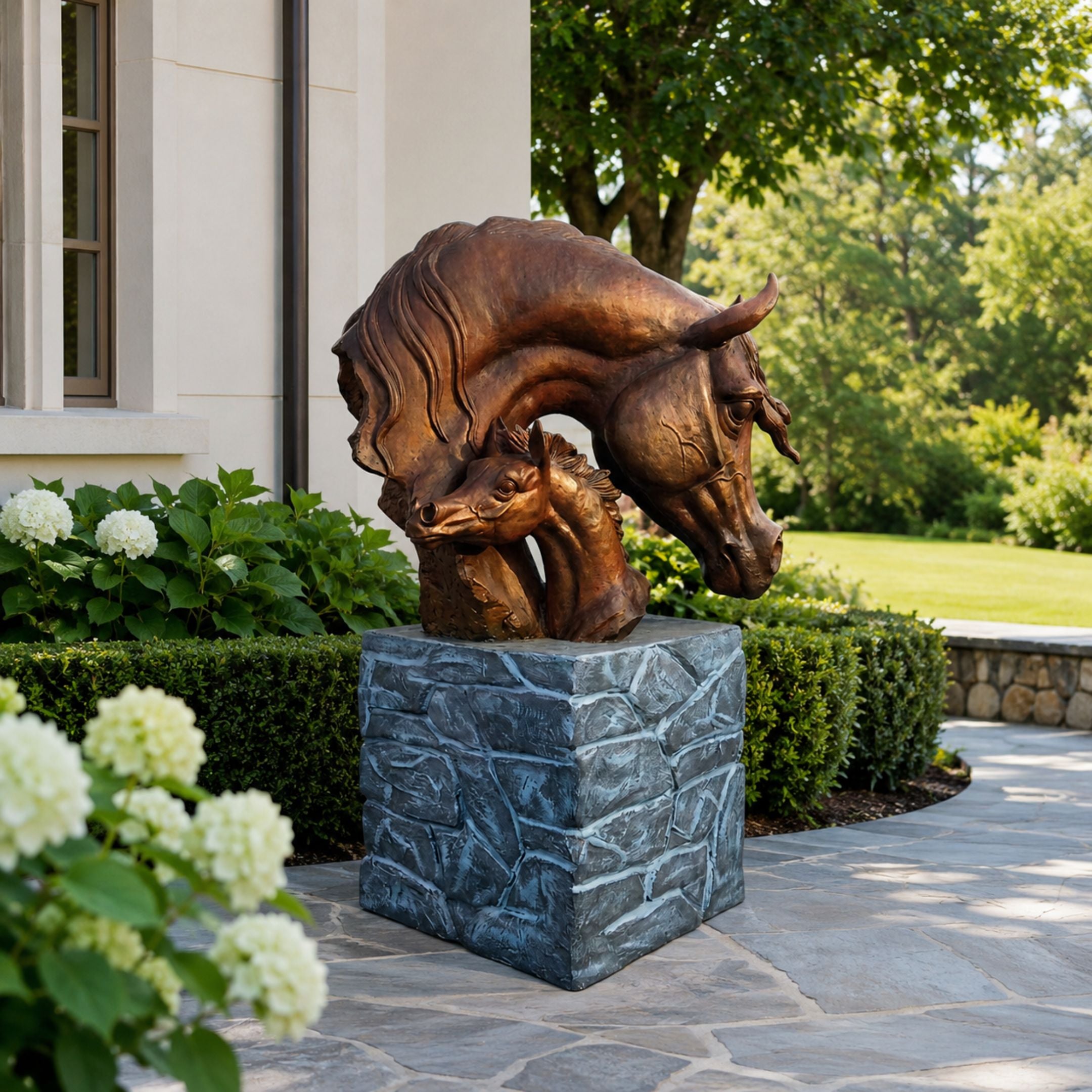 Large Contemporary Mare and Foal Bronze Sculpture, 120cm, mare's neck arching over nestled foal, on a stone-textured pedestal outside a home with greenery.