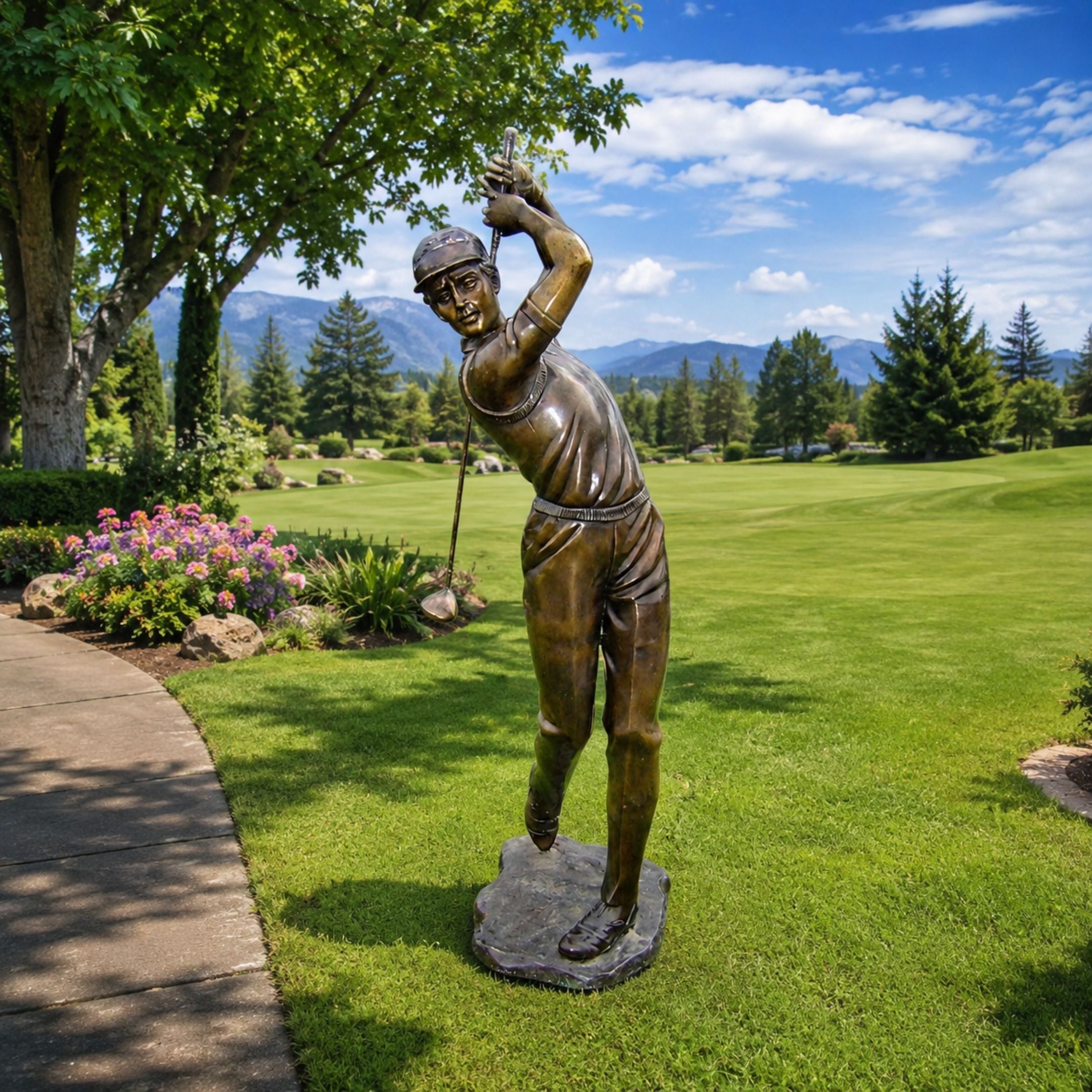 Life-Size Golfer Mid-Swing Bronze Sculpture, 220cm, on a stone base amid a golf course lawn with trees and mountains in the background.