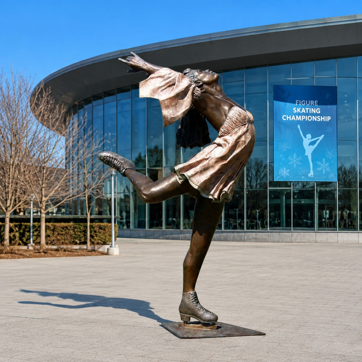 Life-Size Contemporary Female Figure Skater Bronze Sculpture, 220cm, on a paved plaza with one leg raised and arms outstretched before a glass building.