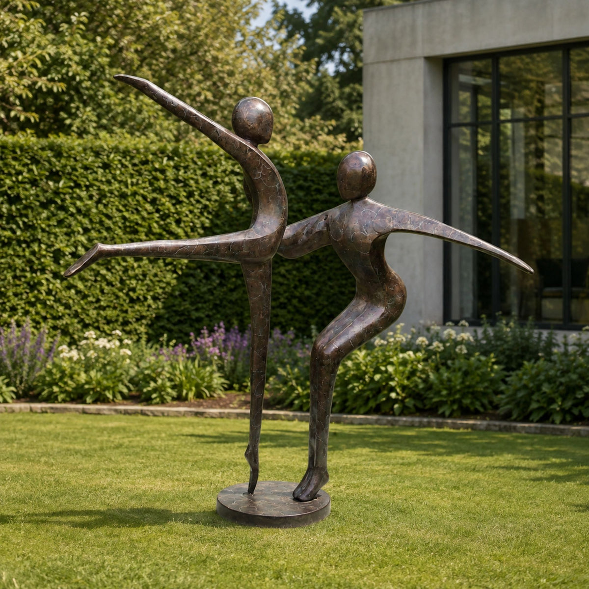 Large Contemporary Dancing Figures Bronze Sculpture, 220cm, two abstract bronze dancers on a round base, set on a lawn near hedges and a modern building.