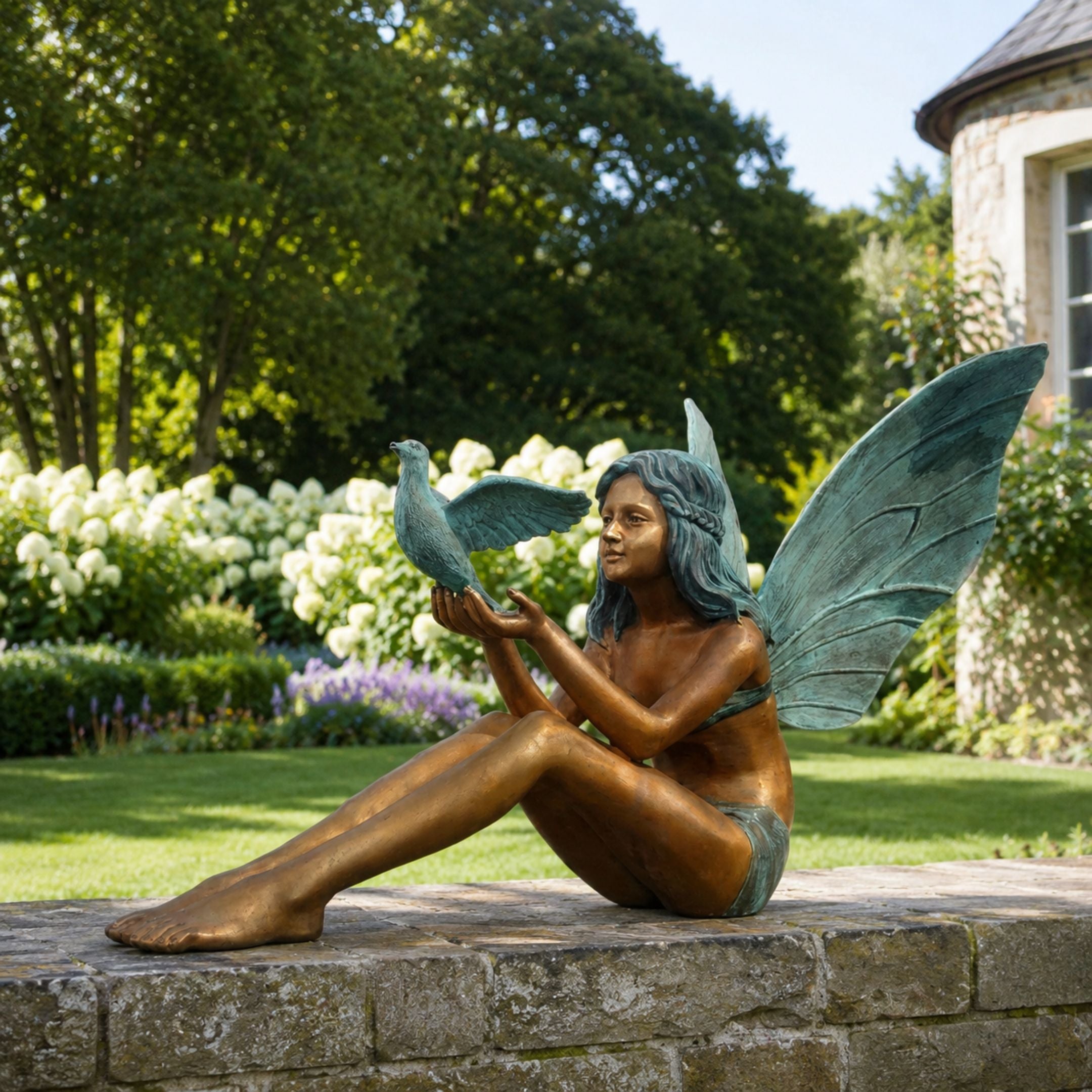 Contemporary Seated Fairy Girl with Dove Bronze Sculpture, 150cm, seated figure with butterfly wings raising a dove on her hand, garden setting on a stone ledge.