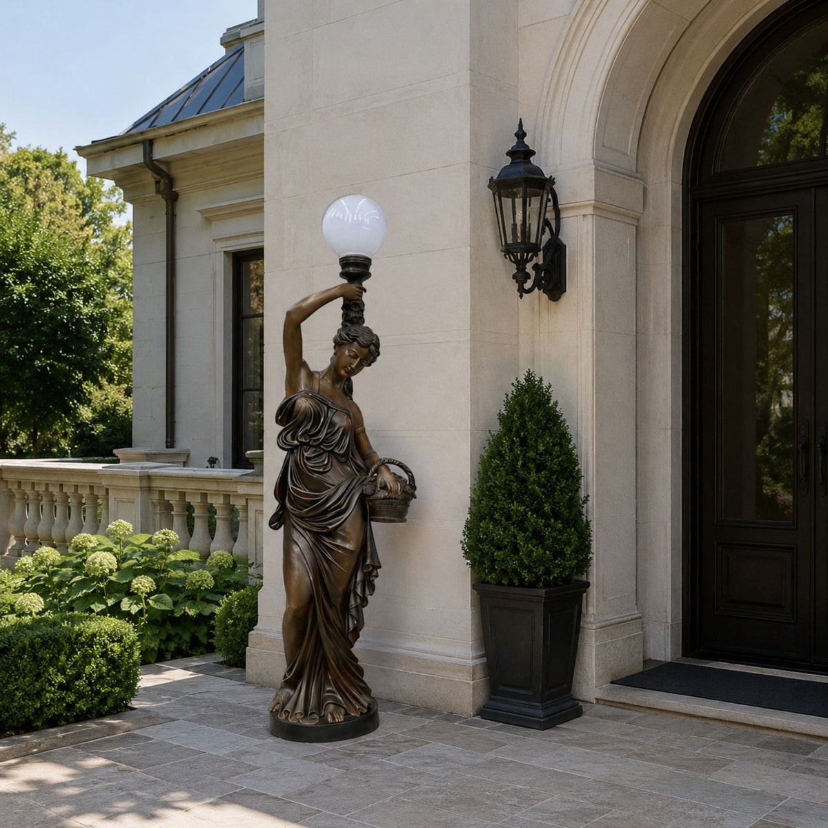 Life-Size Classical Female Figure Bronze Sculpture, 230cm, draped goddess holding a globe lamp and basket, displayed beside an entrance with topiary and stone façade.